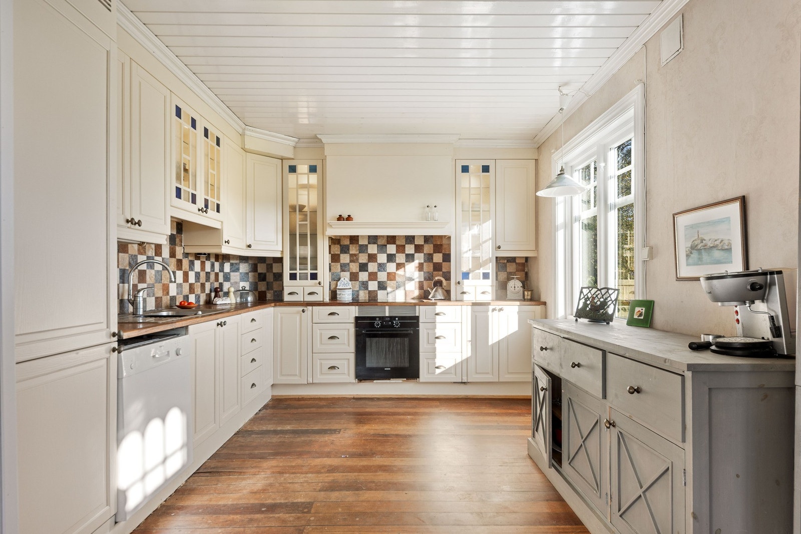 Lyst og trivelig kjøkken med profilert kjøkkeninnredning. Galleribilde