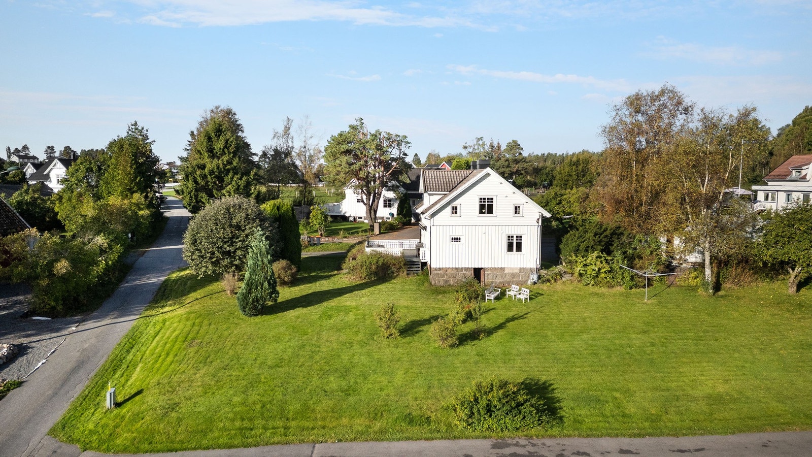 Romslig hagetomt med plen og beplantning. Galleribilde