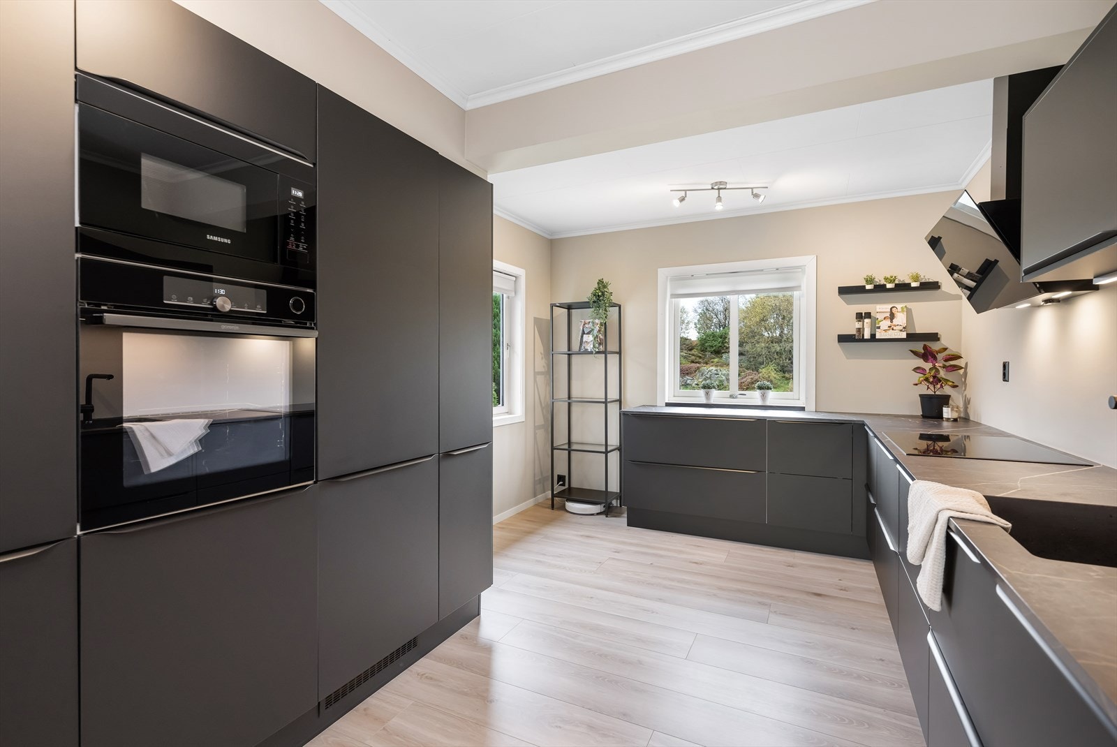 Moderne kjøkkeninnredning fra Designa med glatte, mørke fronter og laminat benkeplate. Galleribilde