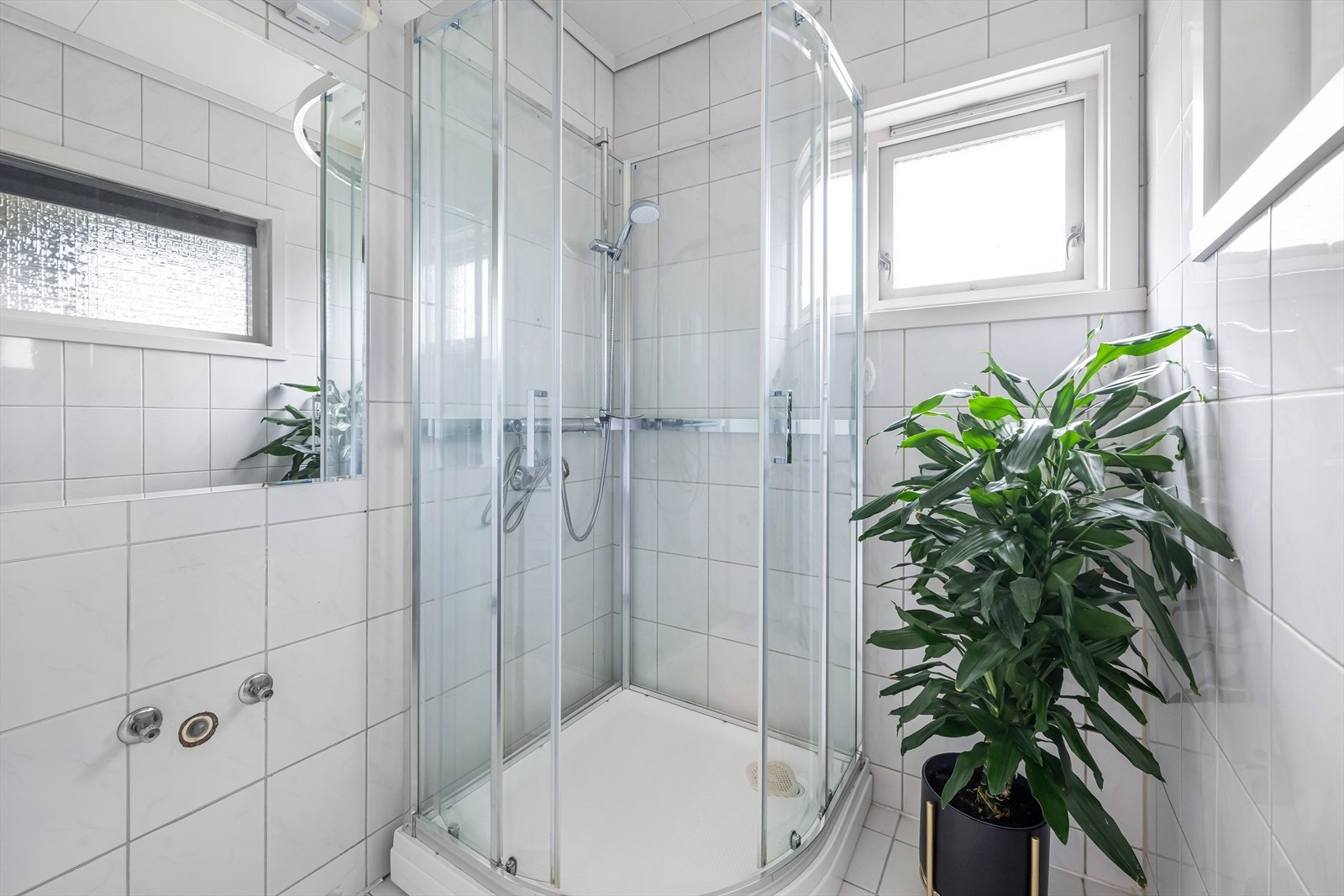 Helfliset bad innredet med dusjkabinett og opplegg til vaskemaskin. Galleribilde