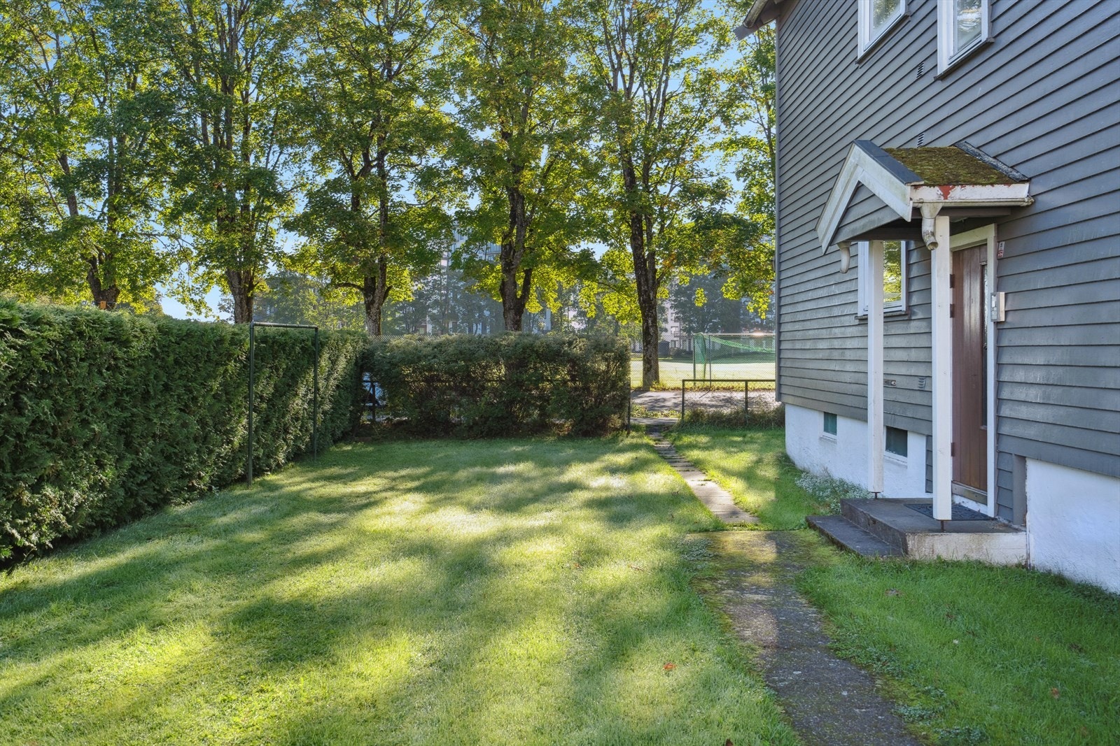 Koselig adkomst til leiligheten via stikkveier og grønne, velstelte fellesområder. Galleribilde