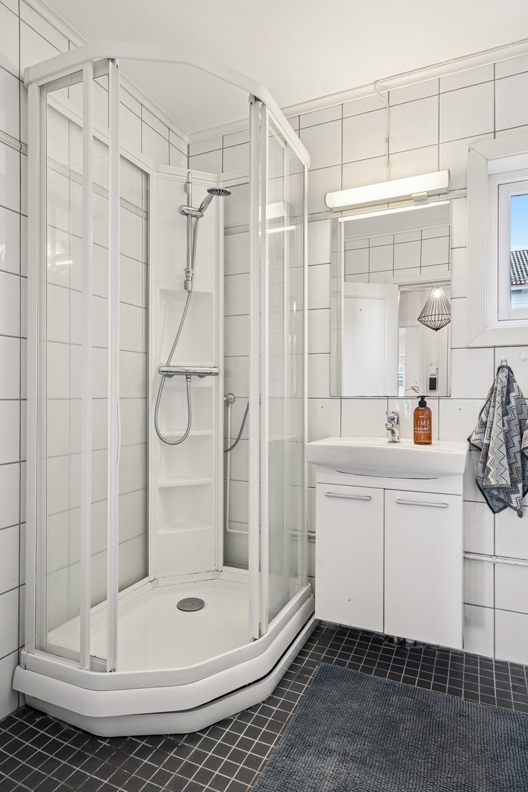 Badet er utstyrt med dusjkabinett, gulvfestet toalett, servant, samt opplegg for vaskemaskin. Galleribilde