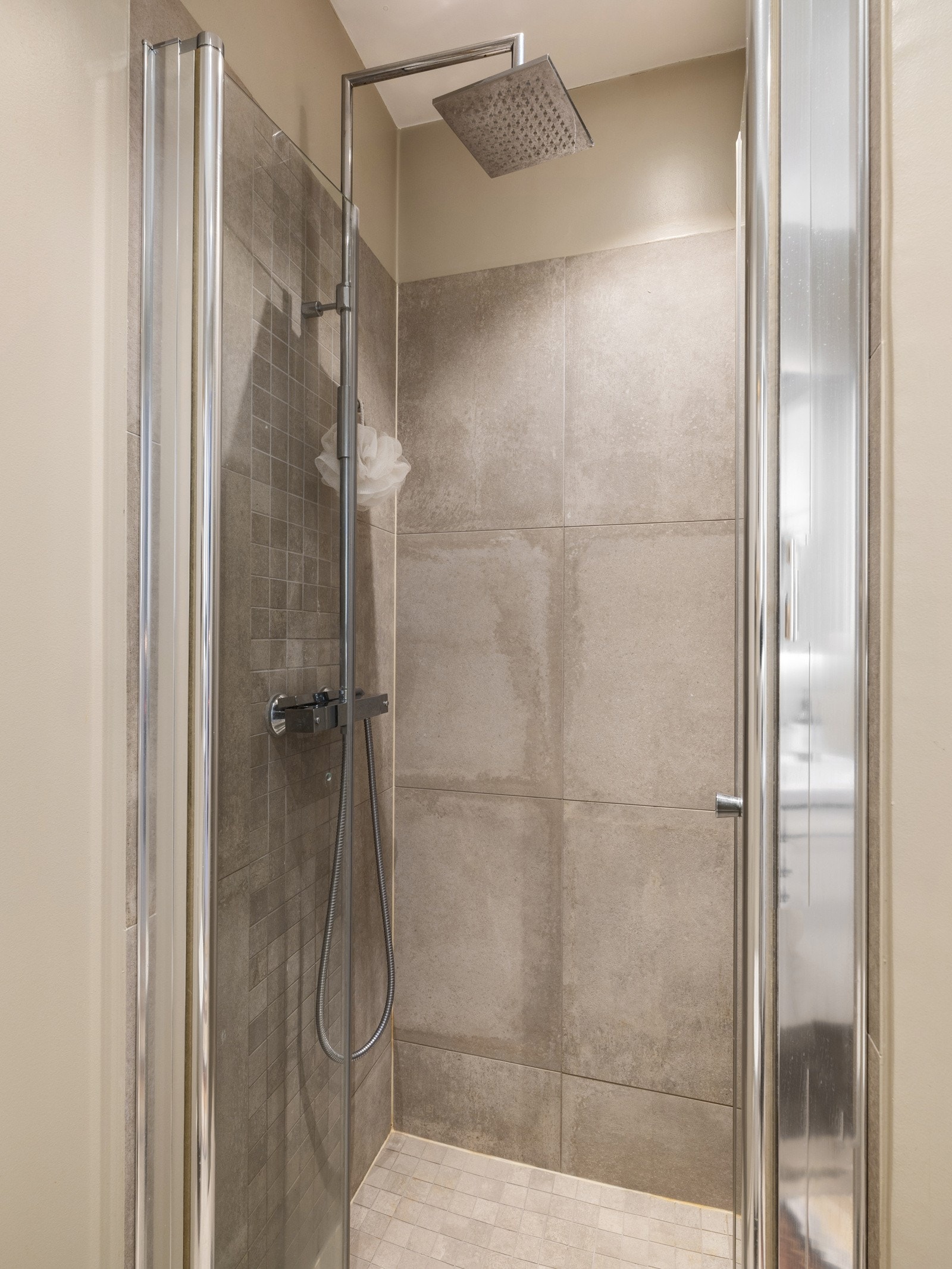 Det er veggmontert toalett, innredning med nedfelt servant og dusjhjørne med glassvegger Galleribilde