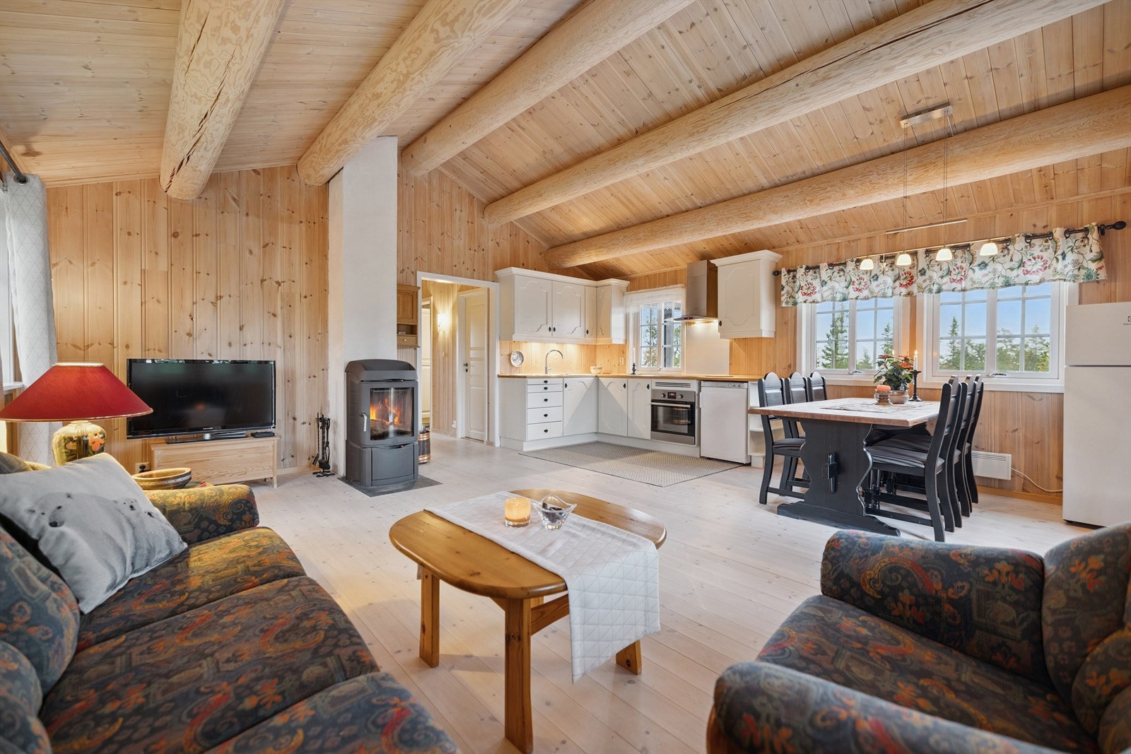 Gjennomgående synlige tømmeråser og behandlet panel på vegger og i tak skaper en lun atmosfære. Galleribilde