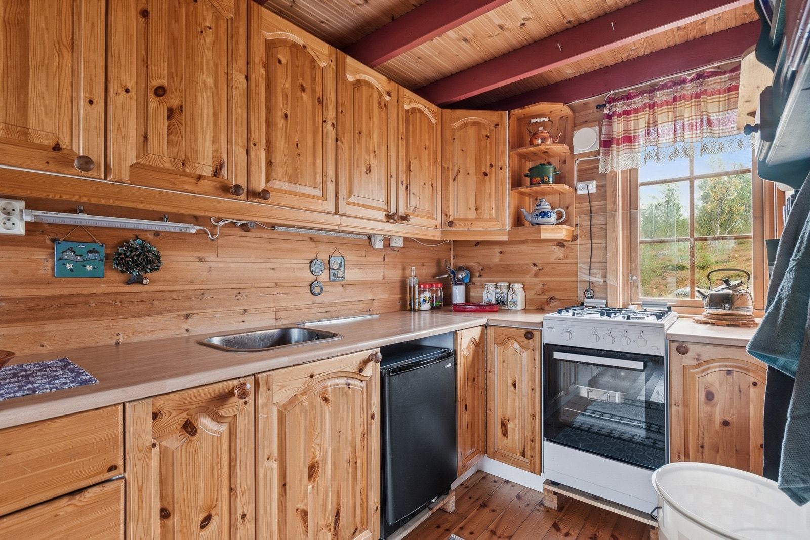 Kjøkkenet har profilerte fronter i tre med frittstående hvitevarer. Galleribilde