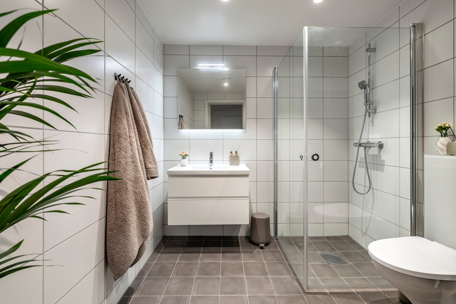 Badet er praktisk plassert i tilknytning til entréen og er pent innredet med flislagte vegger og flislagt gulv med elektriske varmekabler. Galleribilde
