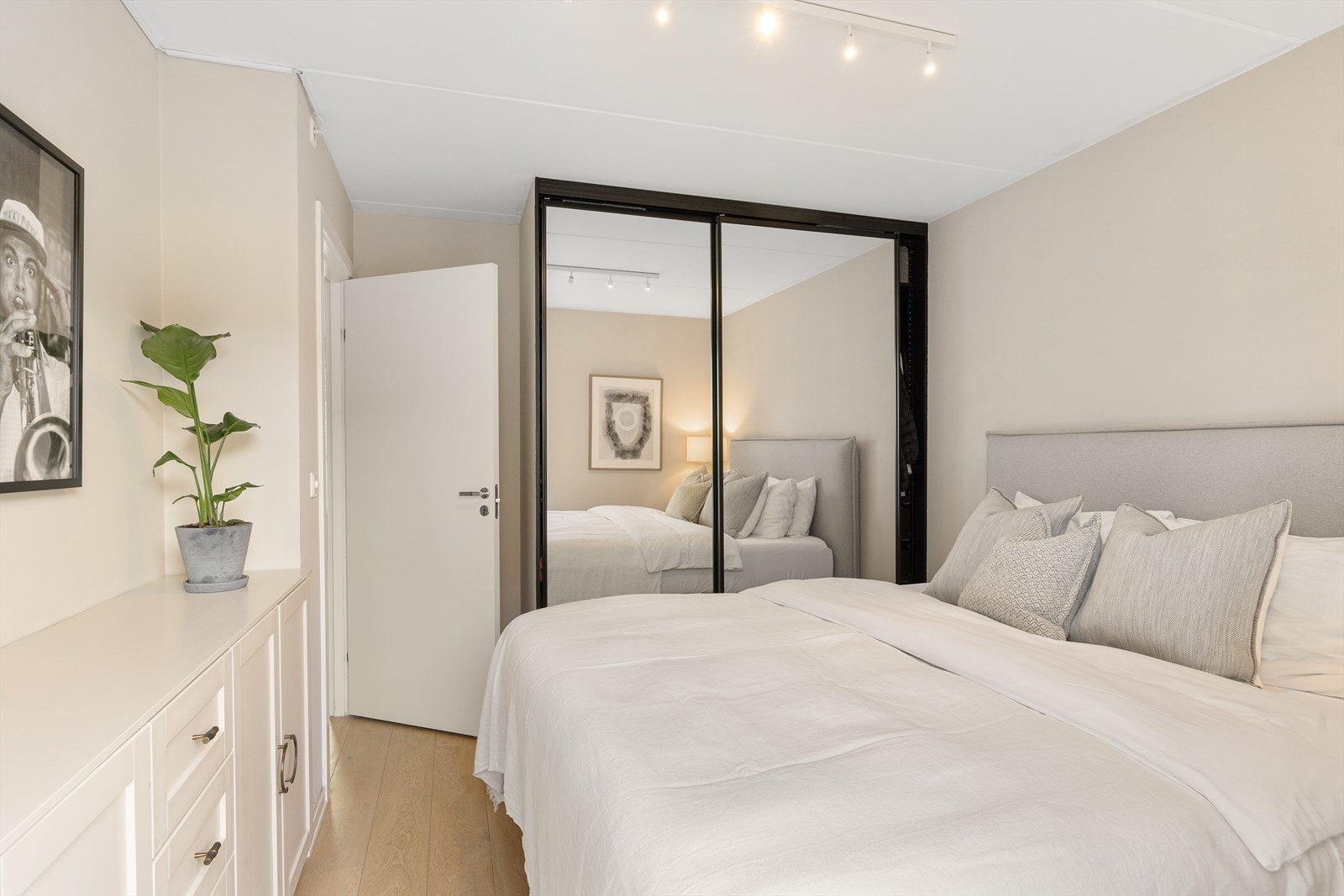 Rommet har også god oppbevaringsplass i en stor skyvedørsgarderobe med speilfronter. Galleribilde