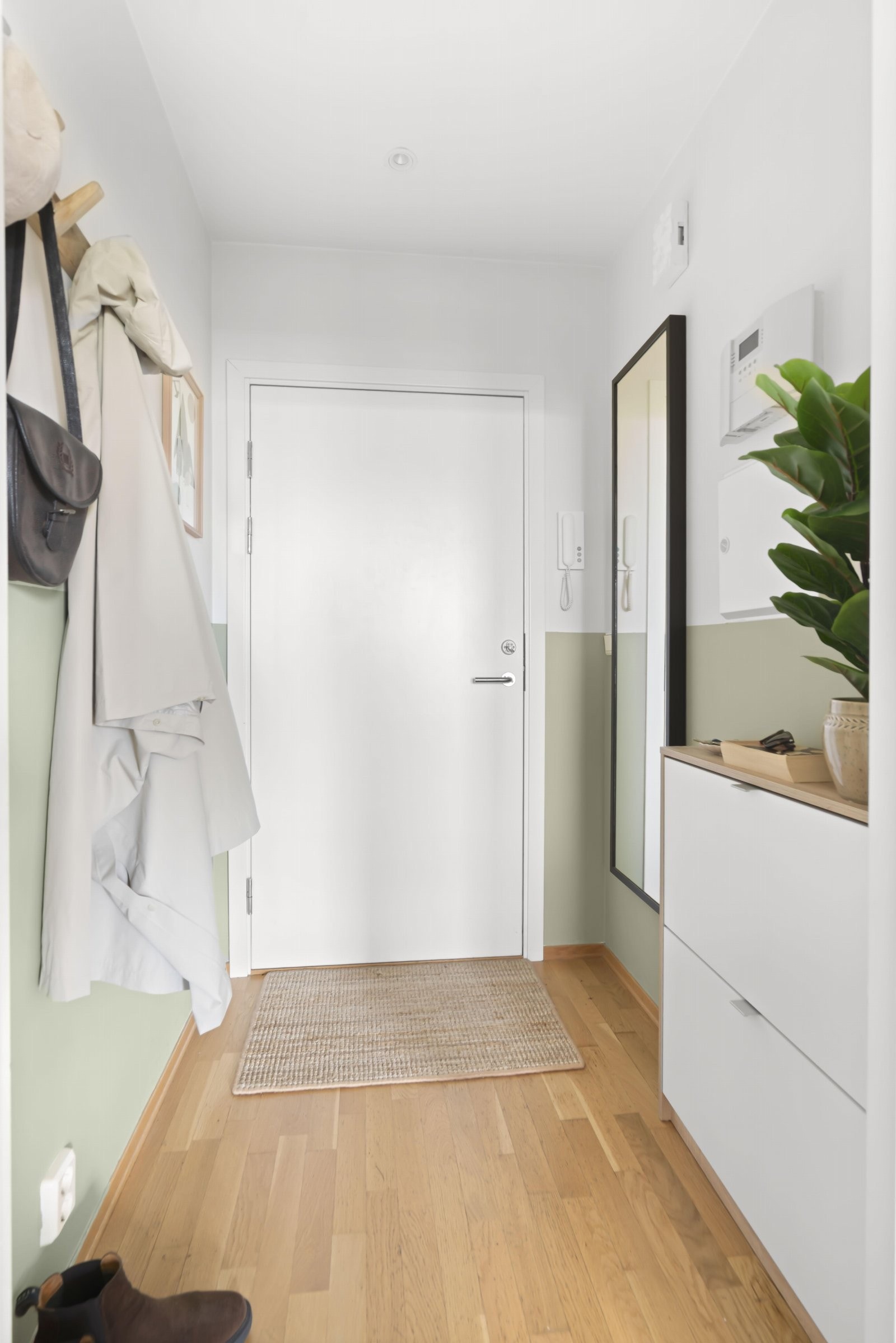 Innbydende og romslig entré med avsatt plass til oppbevaring av yttertøy. Callinganlegg ved ytterdøren. Galleribilde