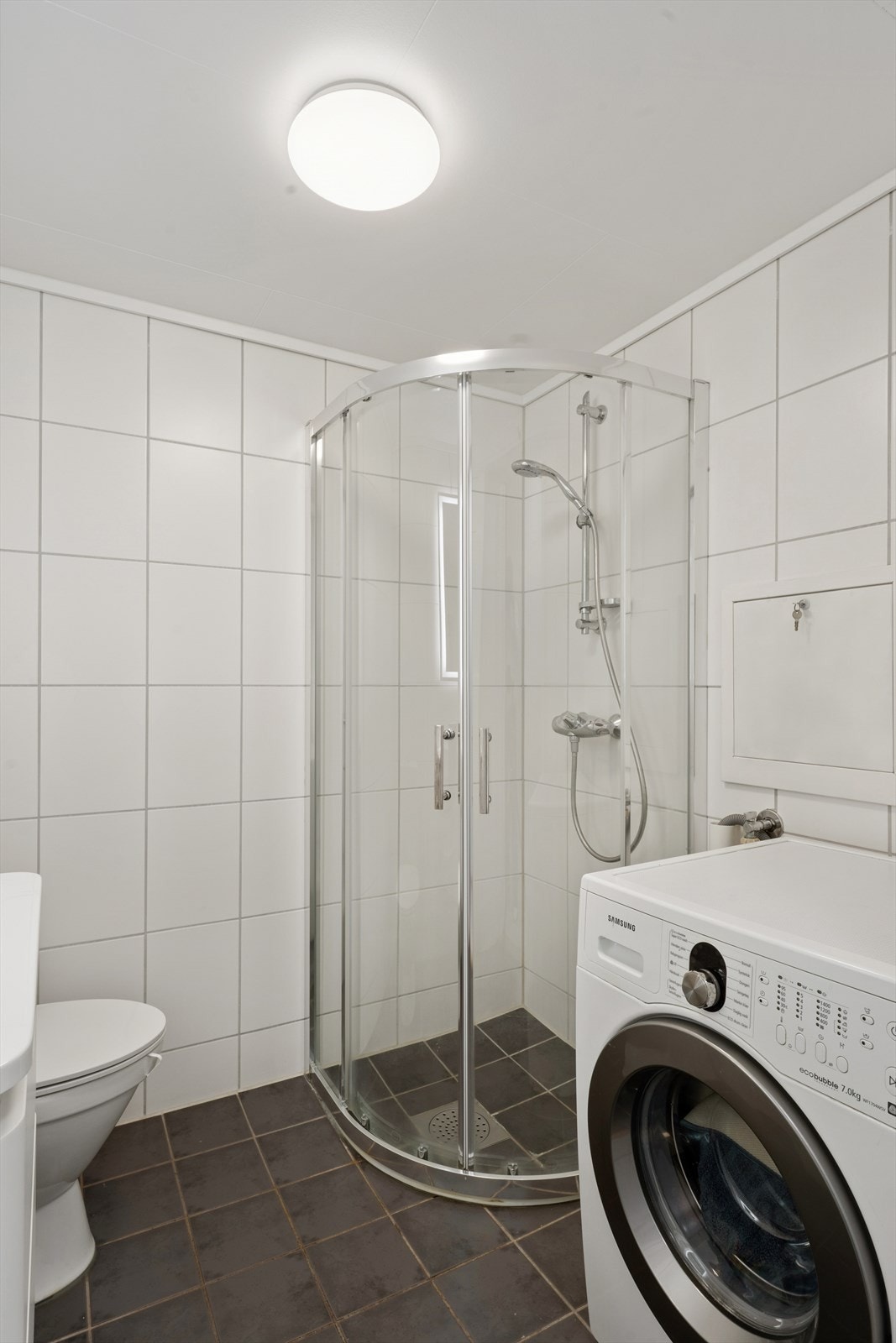 Lyst og delikat bad med flislagte overflater og moderne innredning. Galleribilde