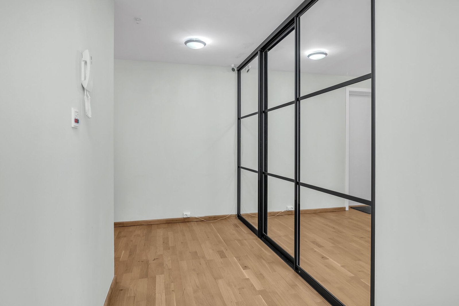 Entréen er innredet med en funksjonell skyvedørsgarderobe med speildører. Galleribilde