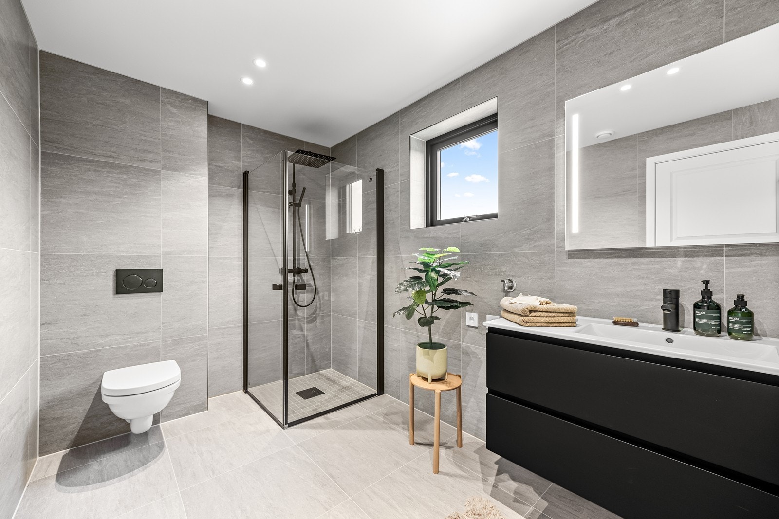 Stort flislagt bad med plass til både vaskemaskin og tørketrommel Galleribilde