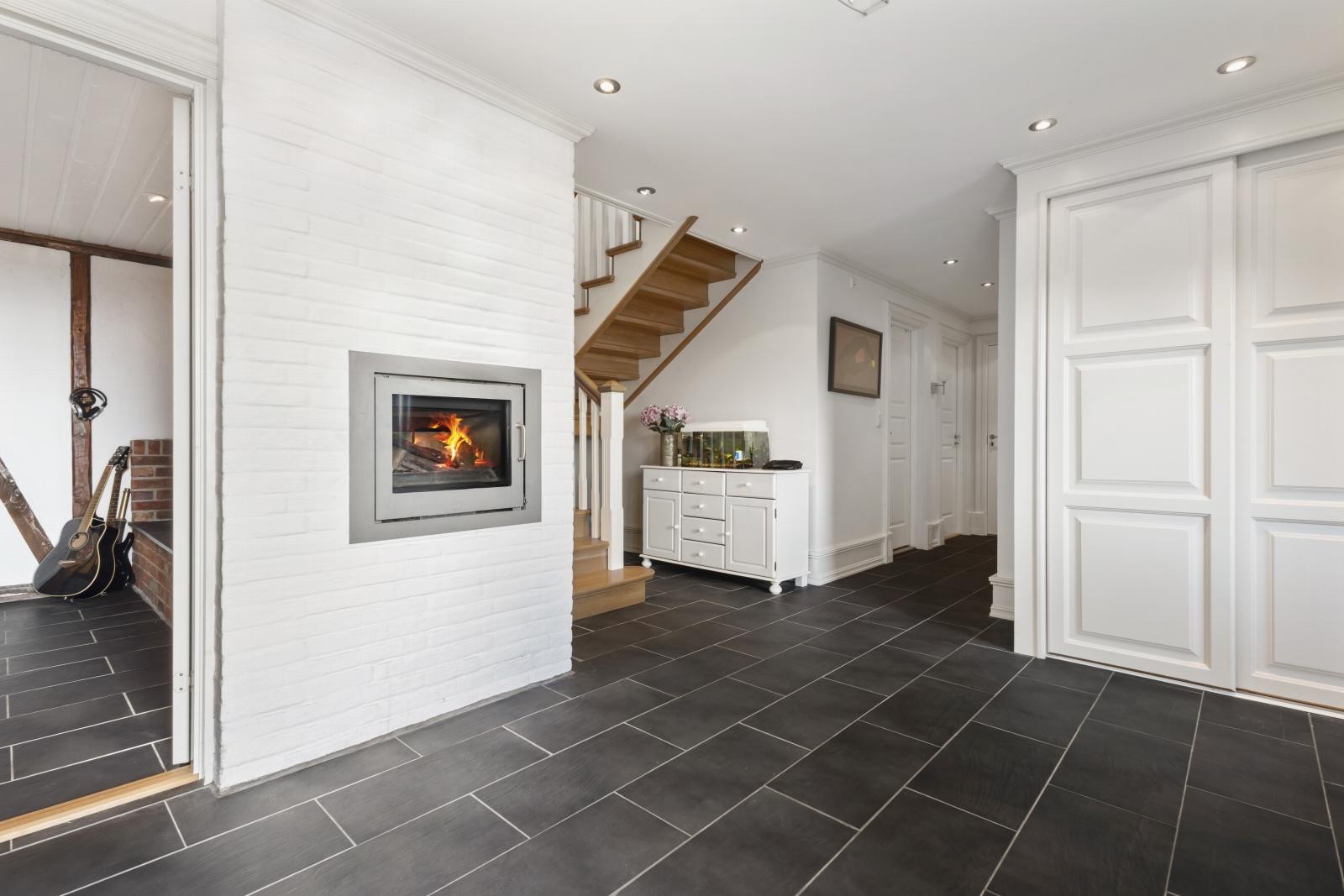 Stor, flislagt entré med god oppbevaringsplass i skyvedørsgarderobe. Møbelsnekret trapp og skyvedørsgarderobe. Galleribilde