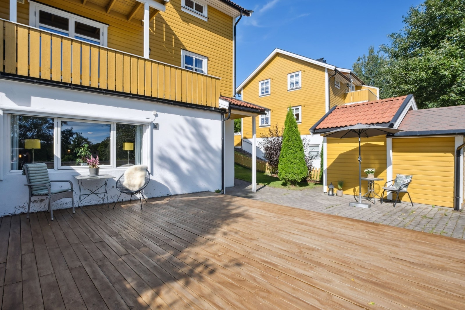 Stor fin uteplass med terrasseplatting og belegningsstein. Galleribilde