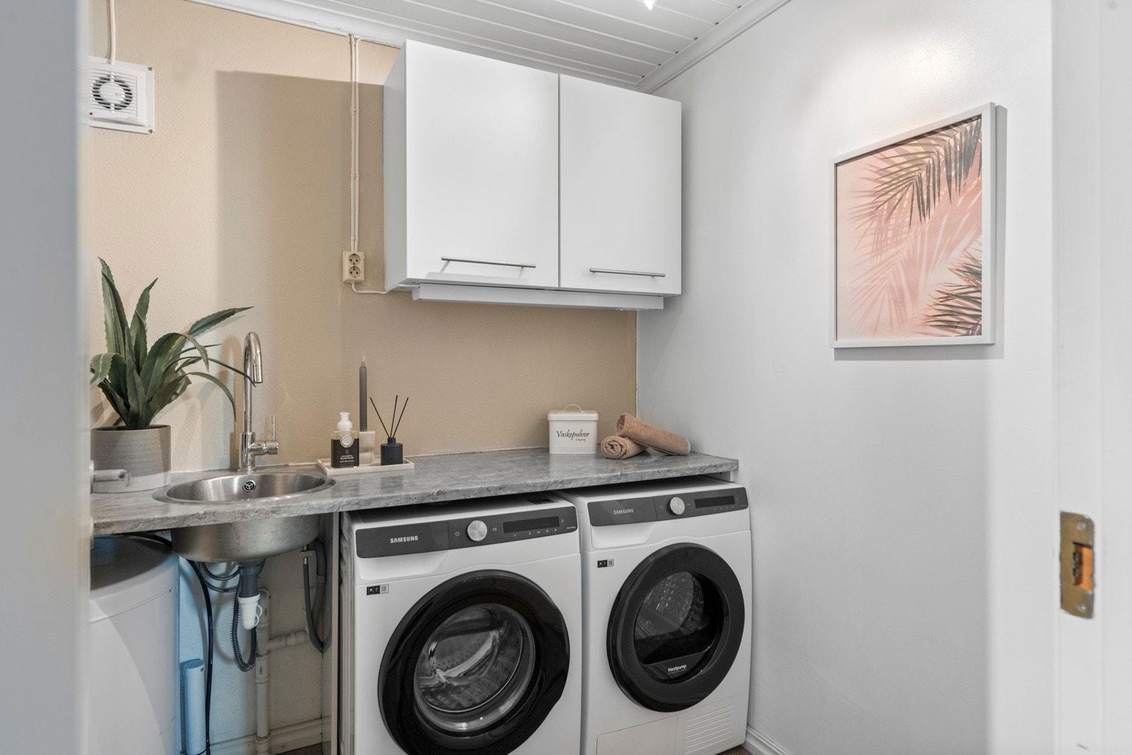 Praktisk vaskerom med opplegg for både vaskemaskin og tørketrommel. Det er også montert varmtvannstank under benkeplaten Galleribilde