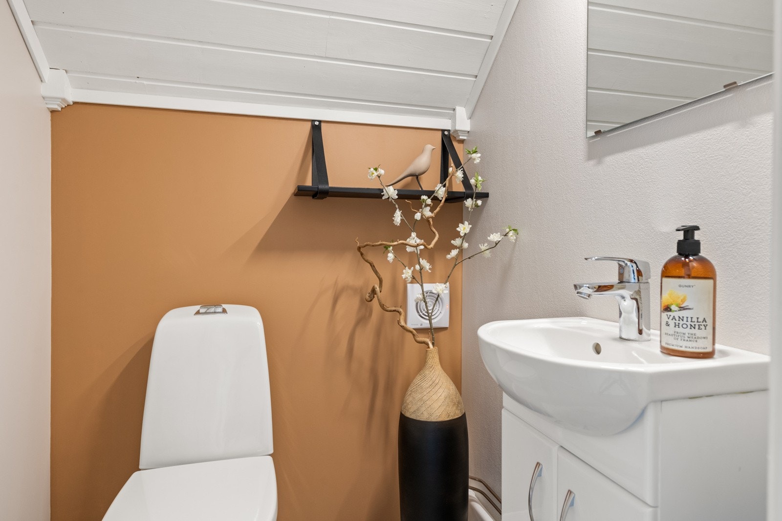 Praktisk toalettrom med toalett og servantskap med ovenpåliggende servant Galleribilde