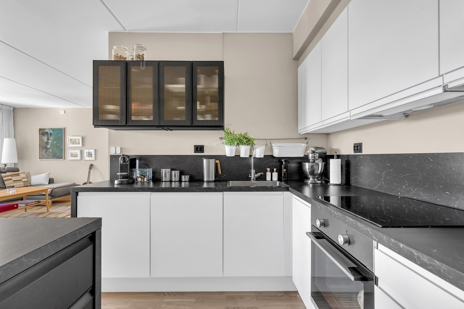 Kjøkkenet er fullt utstyrt med integrerte hvitevarer, og den åpne løsningen mot stuen skaper en innbydende og sosial sone. Galleribilde