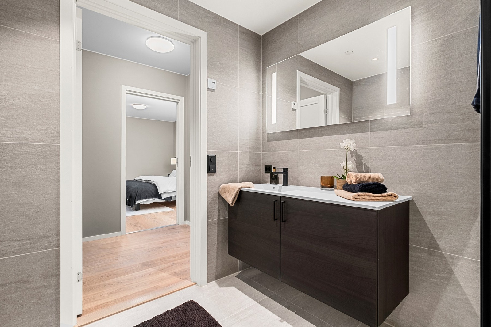 Smakfult og flislagt bad tilhørende soverommet Galleribilde