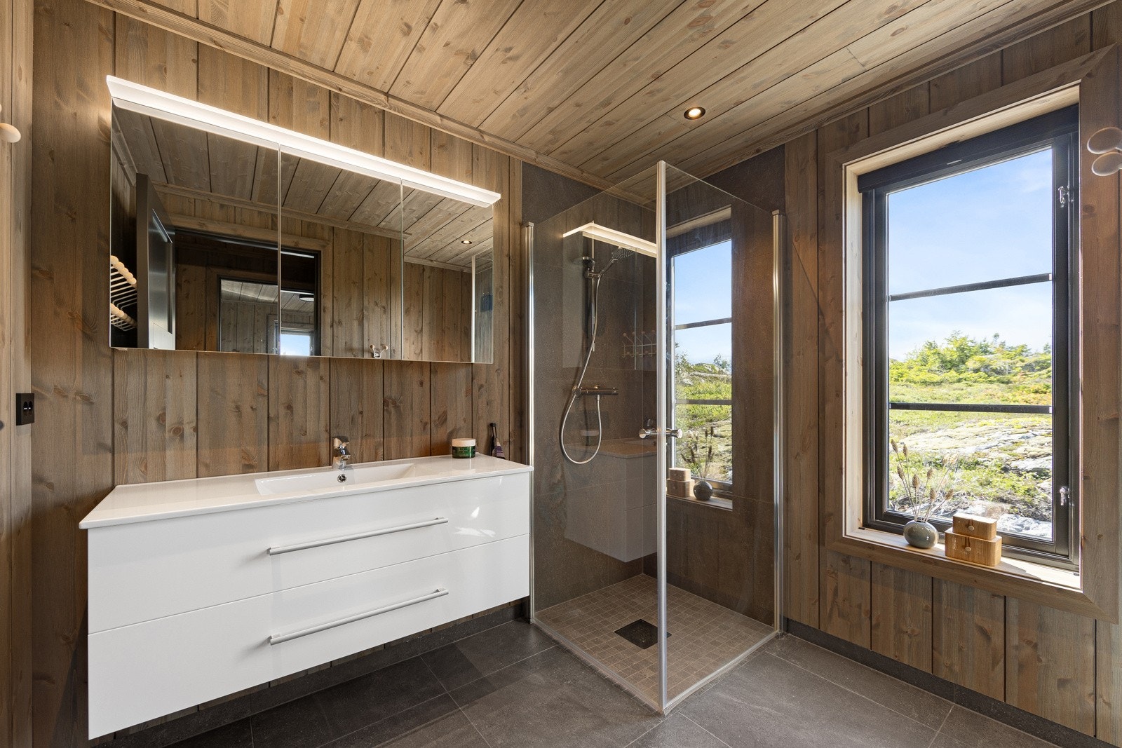 Romslig bad med stor servant med gode skuffer for oppbevaring, og vinduer som slipper inn mye naturlig lys. Galleribilde