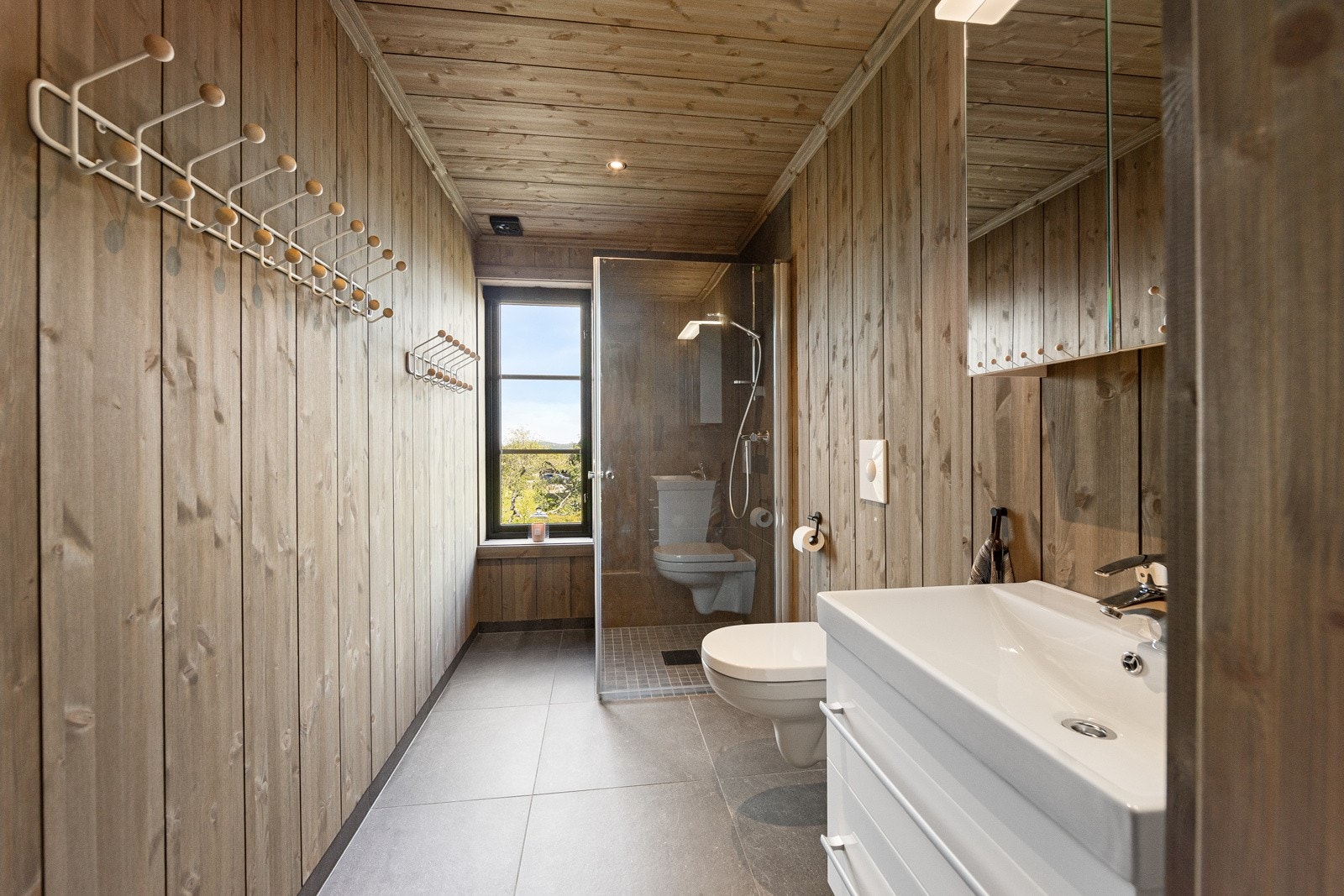 Bad 2 innredet med dusj, vegghengt wc, speil og servant med god oppbevaringsplass. Galleribilde