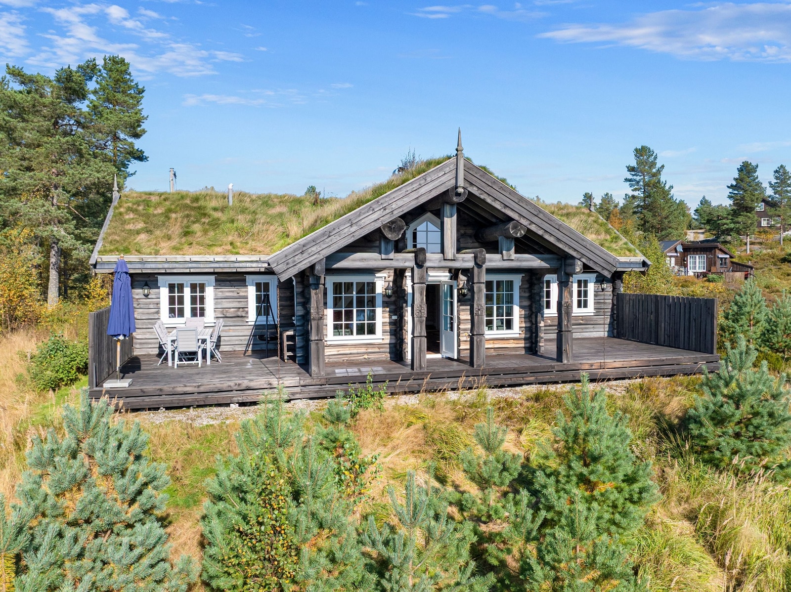 Vakker laftehytte med store terrasser mot vannet Galleribilde