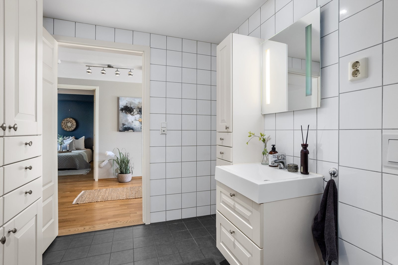 Baderomsinnredningen består av servantskap med dobbelt underskap med kolonialskuffer. Over denne er det dobbel stikkontakt. Badet har også flere høyskap med både skuffer og seksjoner med sidehengslede dører som gir suverent med oppbevaringsplass. Galleribilde