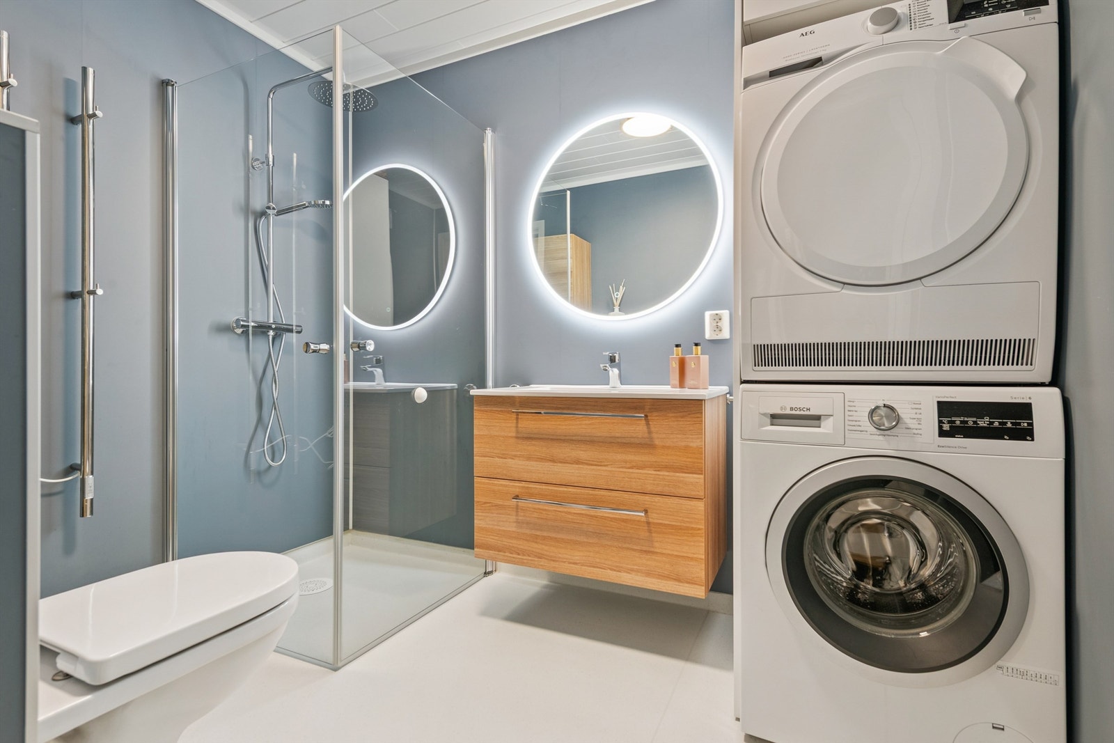 Rommet er utstyrt med servant, vegghengt toalett, dusjhjørne og opplegg for vaskemaskin. Galleribilde