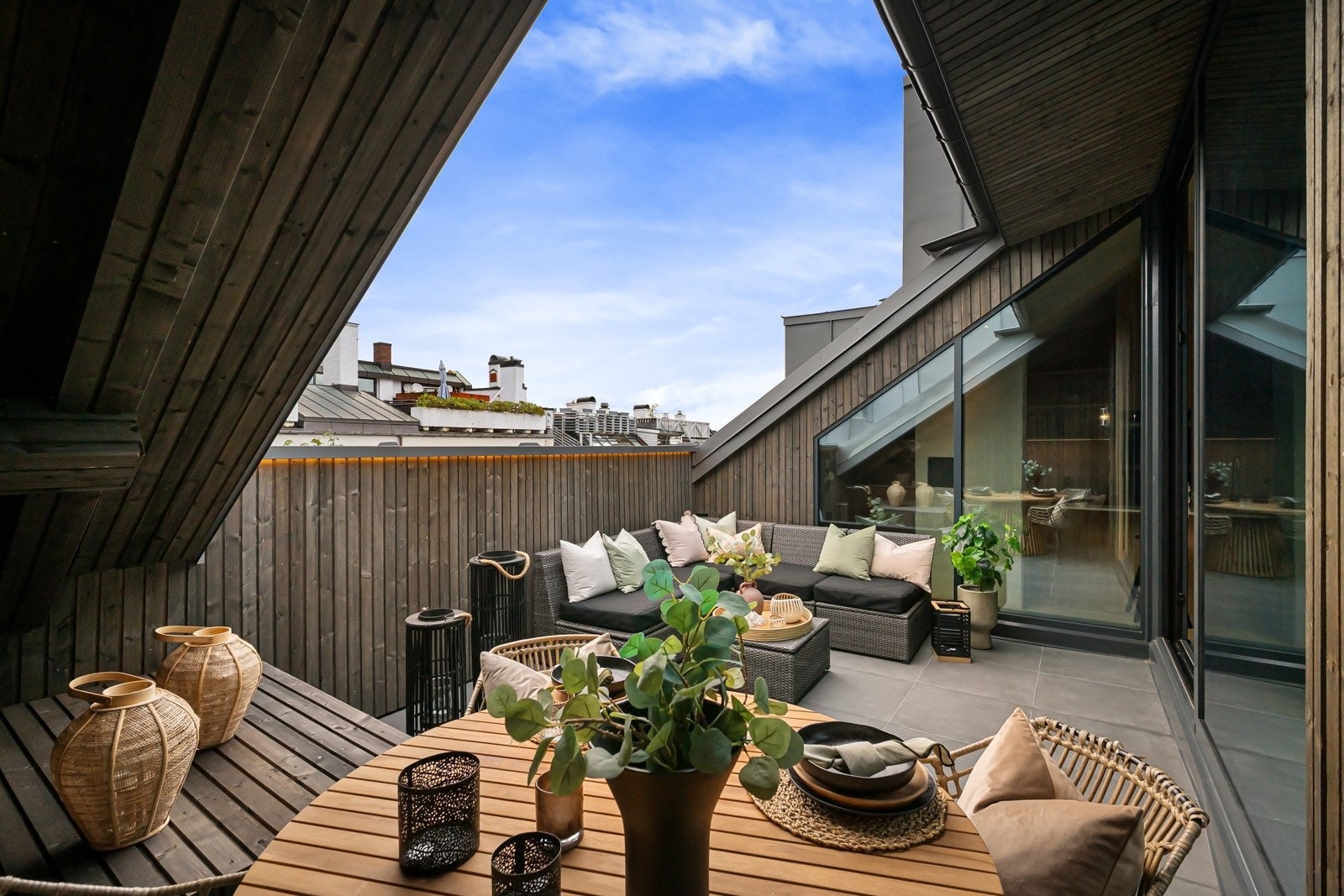 Terrassen har varmekabler under flislagt dekke, panelkledd rekkverk med ledstripe i front og skjermende skråvegger som følger takvinkelen. Galleribilde