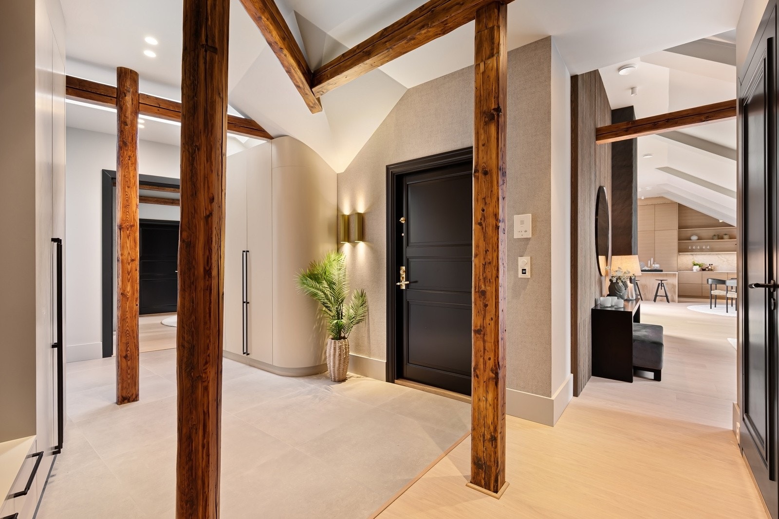 Hallen har flotte storformatfliser på gulvet med gulvvarme, innerdørene er mørke og fotlistene er brede med skjult elanlegg i bakkant. Galleribilde