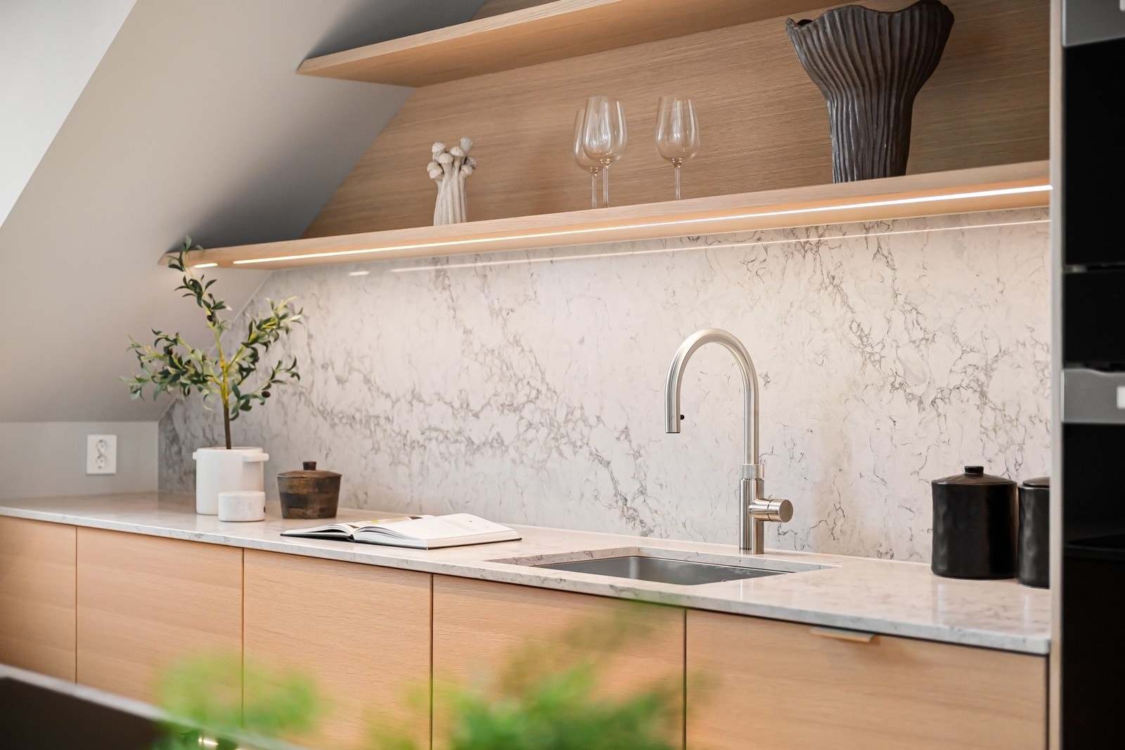 Quooker-kran gir kokende vann og kaldt vann med kullsyre, og det er nedfelt stikk i kjøkkenøya og i benken. Så er alle hvitevarer integrert, for et sømløst uttrykk. Galleribilde