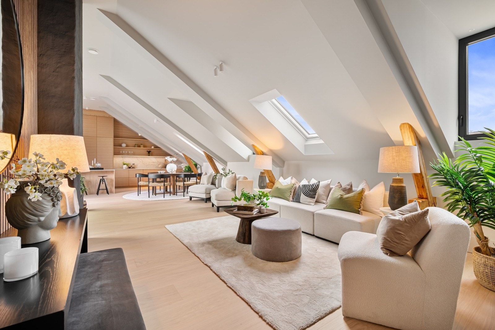 Synlige tak- og veggbjelker gir et rustikk hint mot de ellers strøkne overflatene. Galleribilde