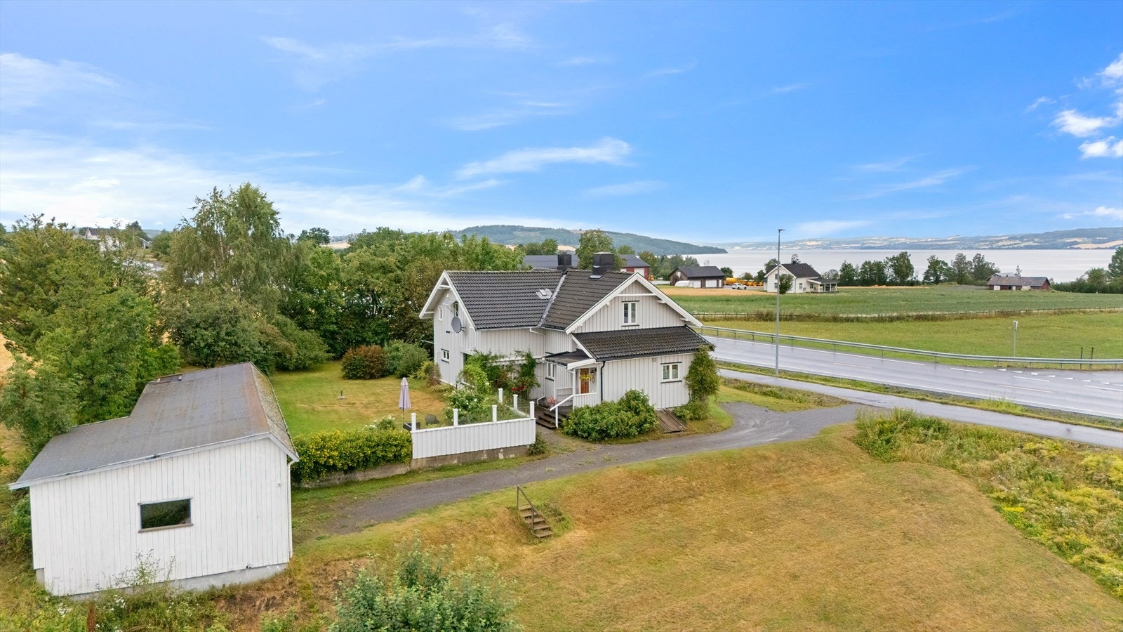 Romslig hage som ligger på begge sider av innkjøringen/ gårdsplassen og ved garasjen Galleribilde