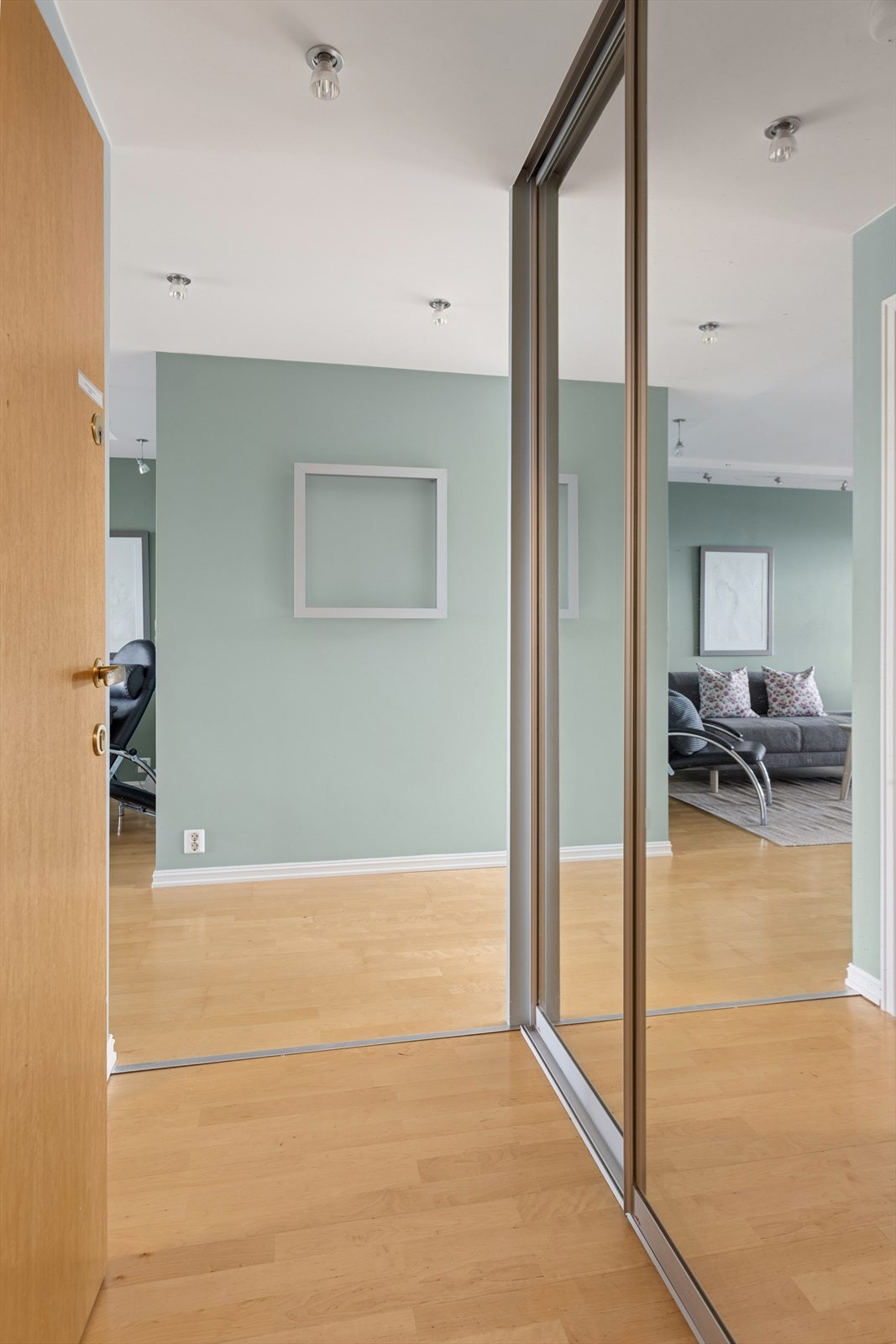 Velkommen inn. Her er det god plass til å henge fra seg yttertøy i en romslig skyvedørsgarderobe med speilfronter. Galleribilde