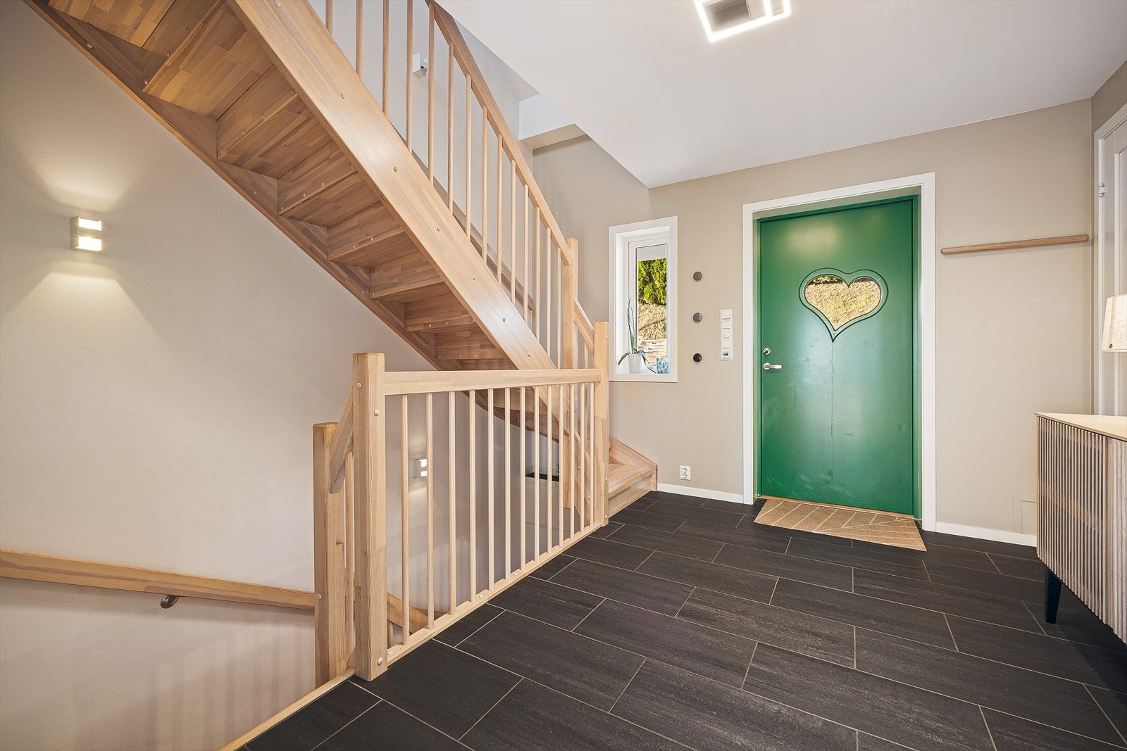 Inngangspartiet lyst og romslig. Her har en mulighet til å gå opp og ned i etasjene, inn til badet som ligger til venstre eller rett frem og inn til stuen Galleribilde