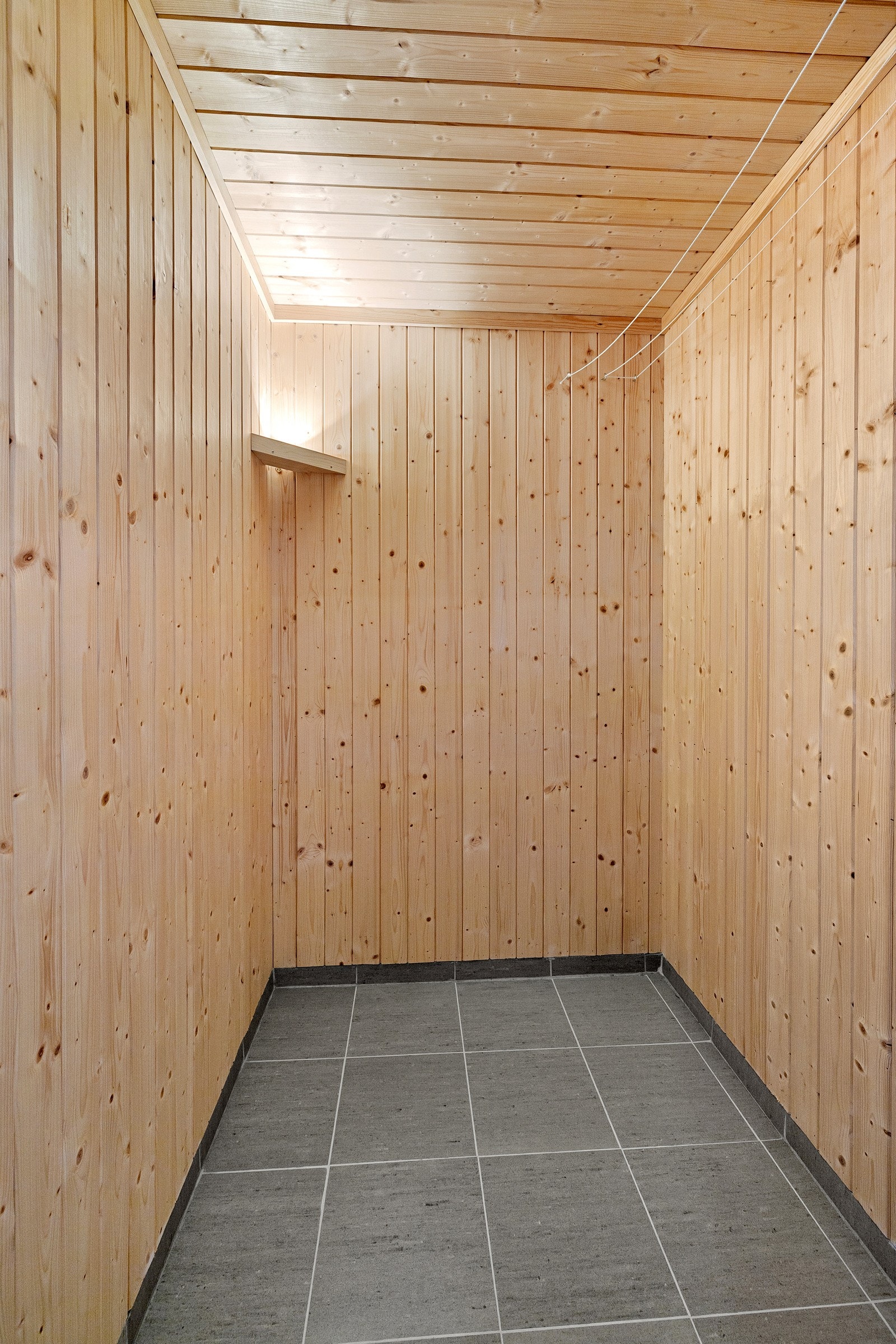 Badstuen har flislagt gulv samt vegger og tak kledd med trepanel, noe som gir en tradisjonell og lun atmosfære. Det er ferdig opplegg for badstueovn. Galleribilde