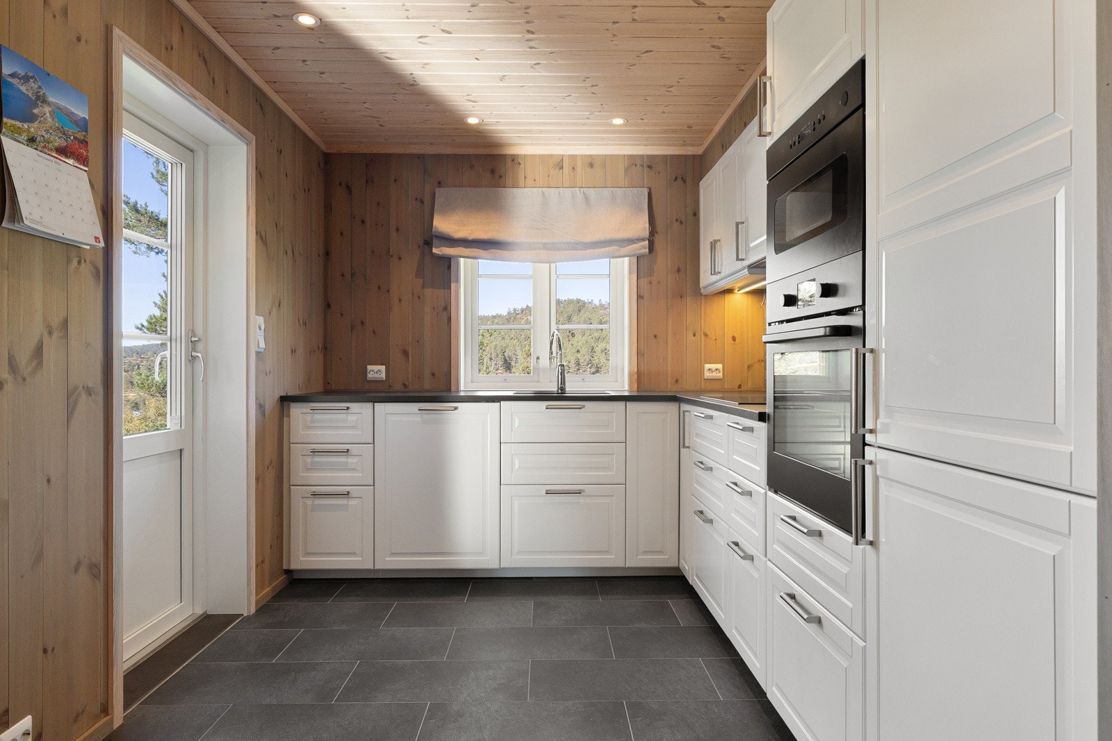 Kjøkkenet har innredning med profilerte fronter og benkeplate i laminat. Galleribilde