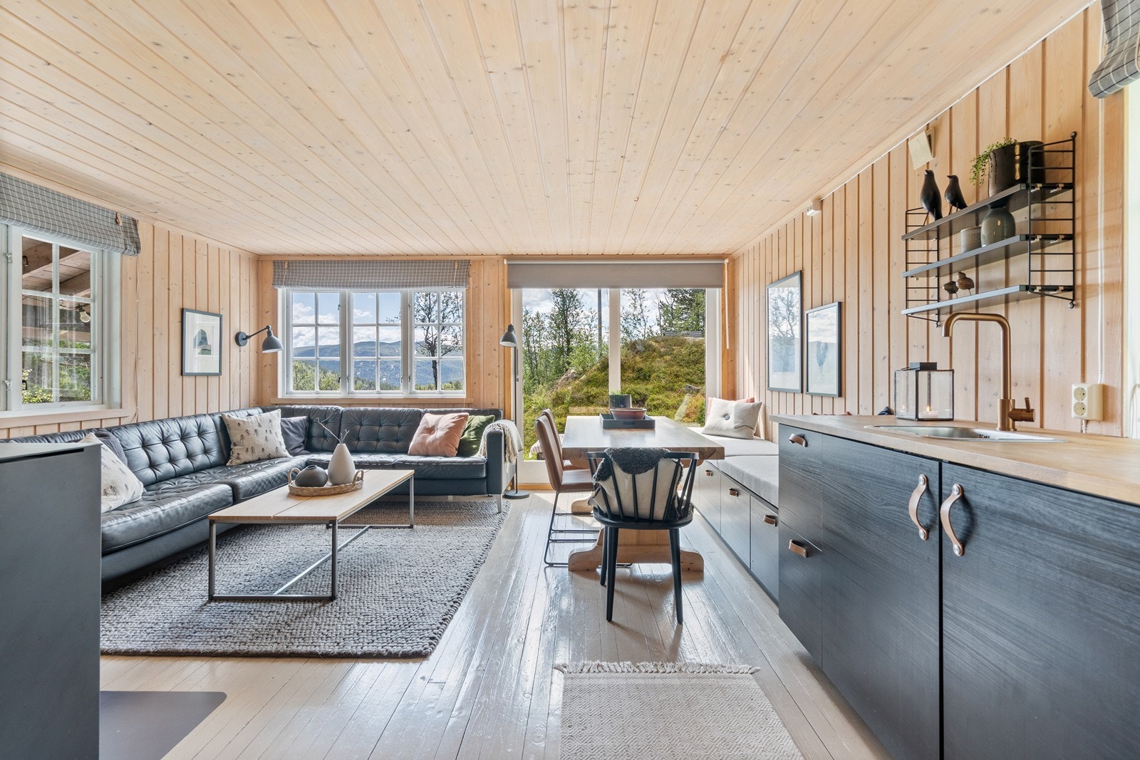 Stue og kjøkken i åpen løsning skaper en romslig og sosial arena. Generøse vindusflater gir godt med naturlig lys og lar den nydelige utsikten komme til sin rett. Galleribilde