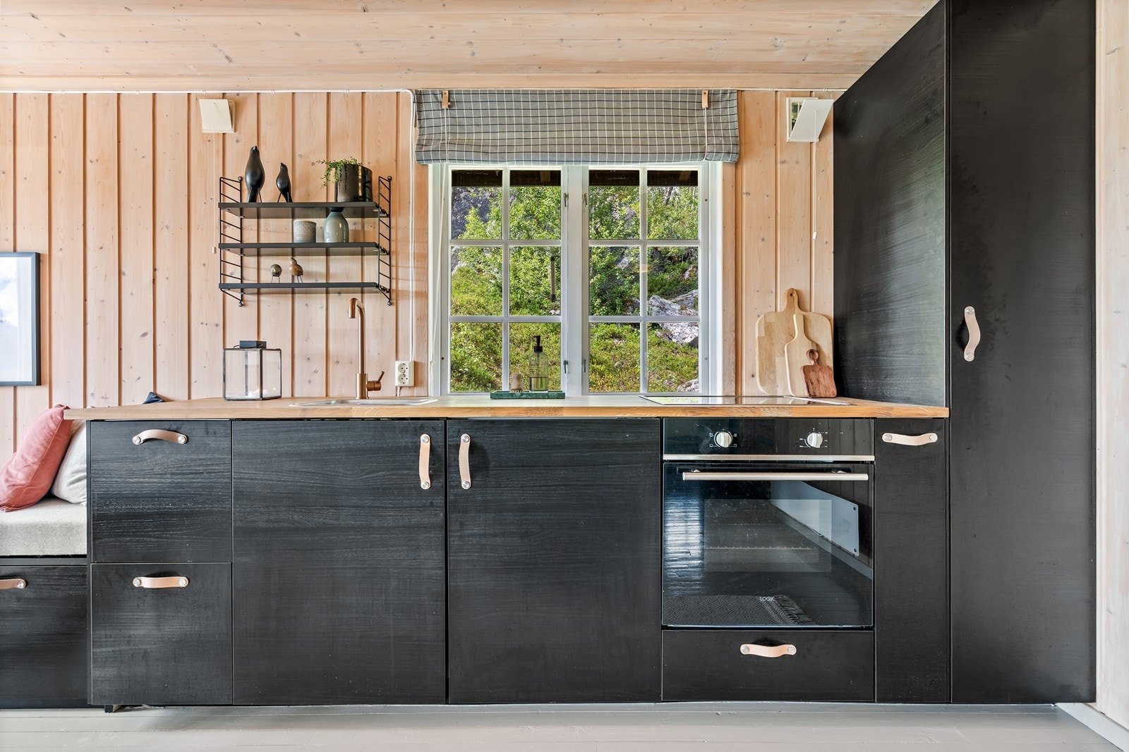 Pen, plassbygget kjøkkeninnredning i mørk utførelse, med god oppbevarings- og arbeidsplass. Galleribilde