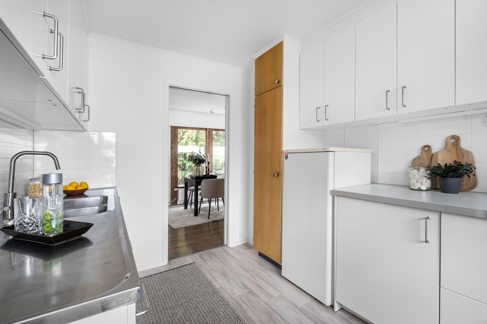 Kjøkken med hvitevarer og plass til frokostbord Galleribilde