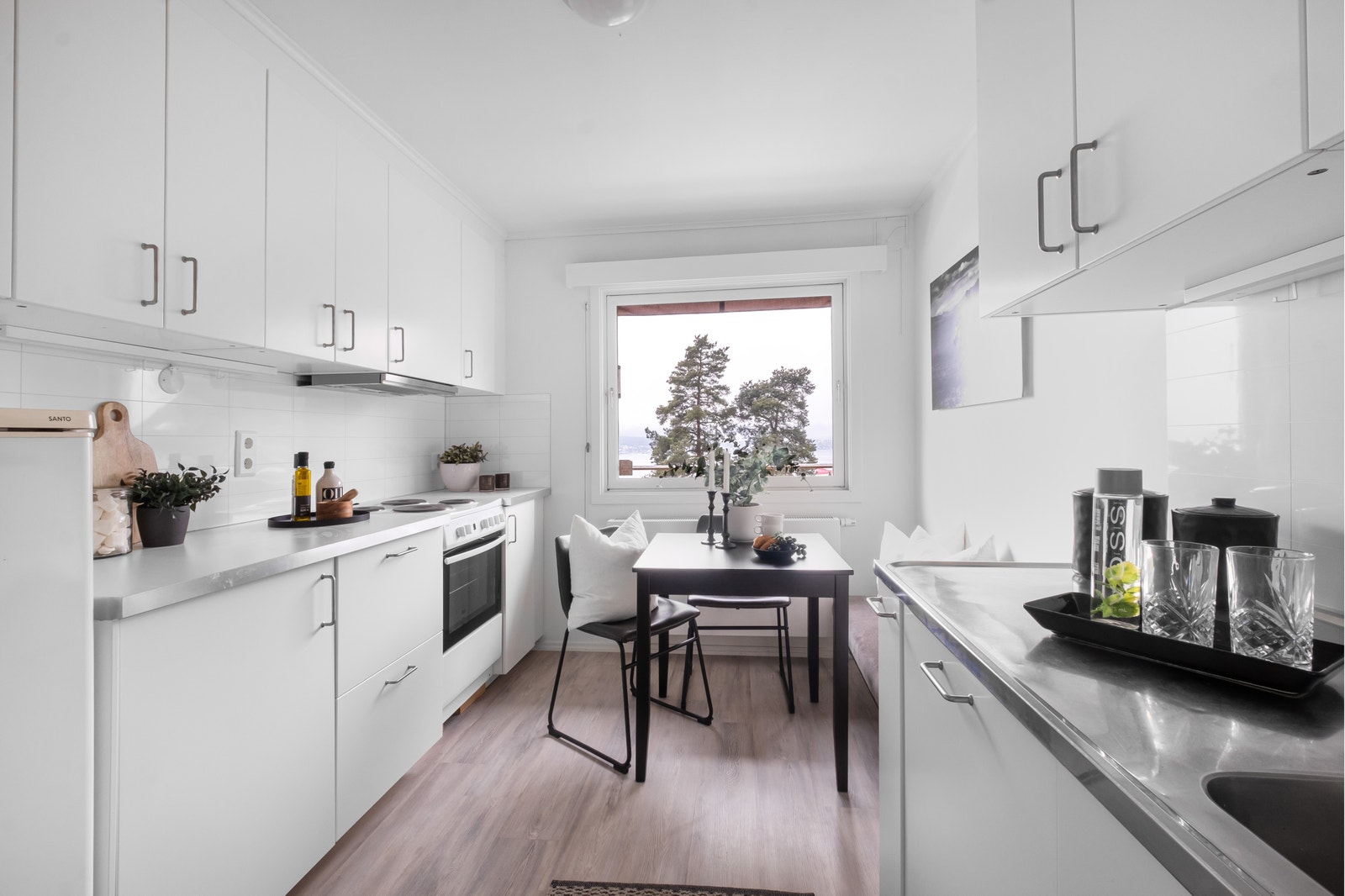 Kjøkken med hvitevarer og plass til frokostbord Galleribilde