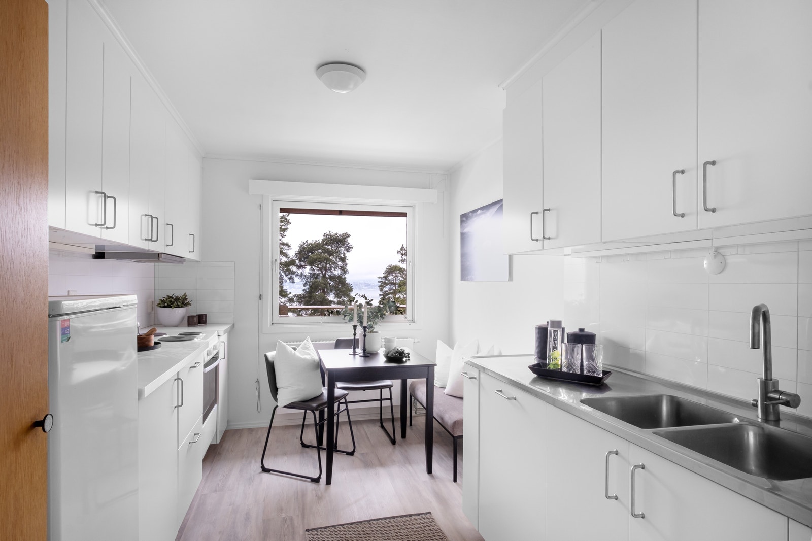 Kjøkken med hvitevarer og plass til frokostbord Galleribilde