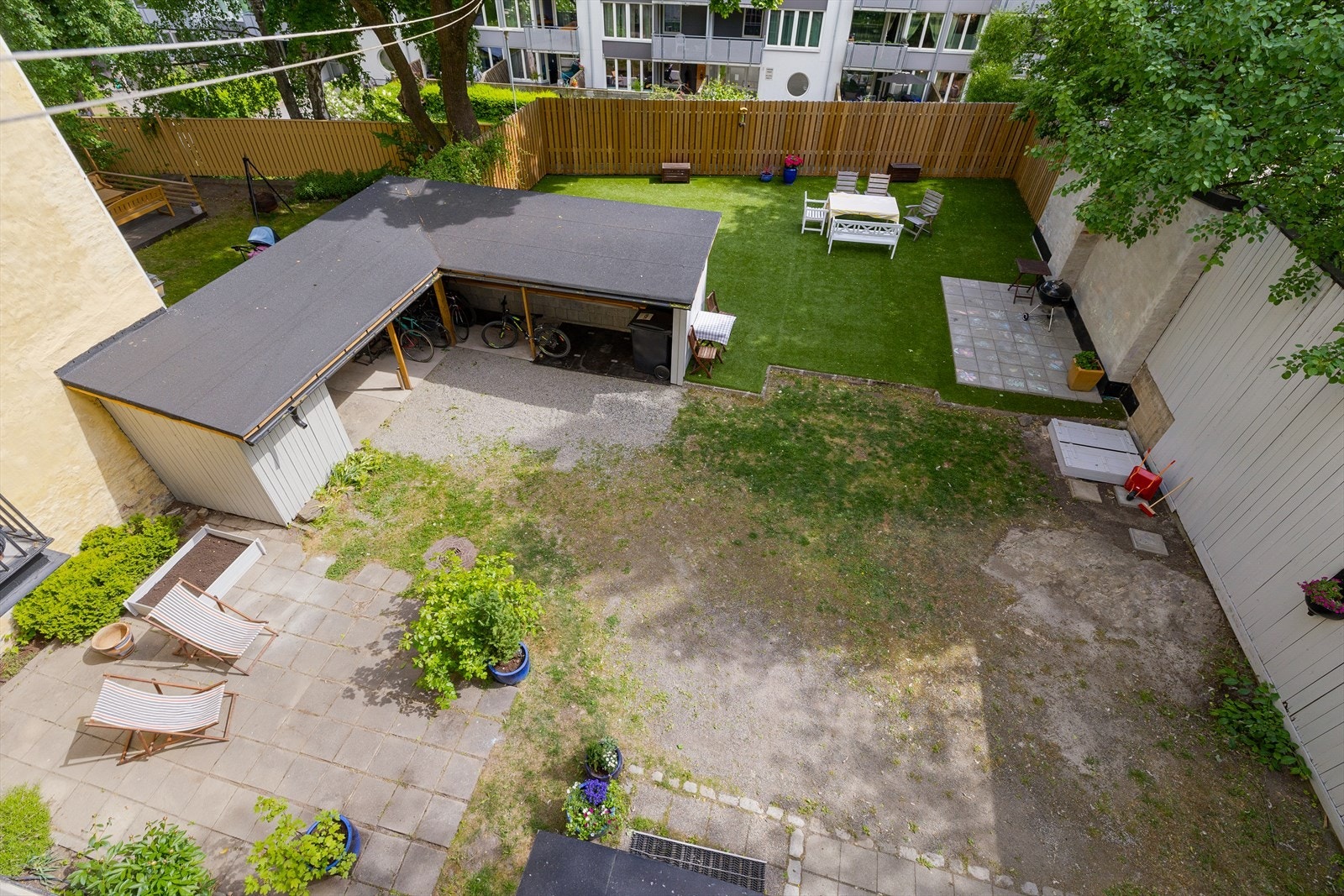 Pent opparbeidet bakgård med sittegrupper, grill og sykkelparkering. Galleribilde