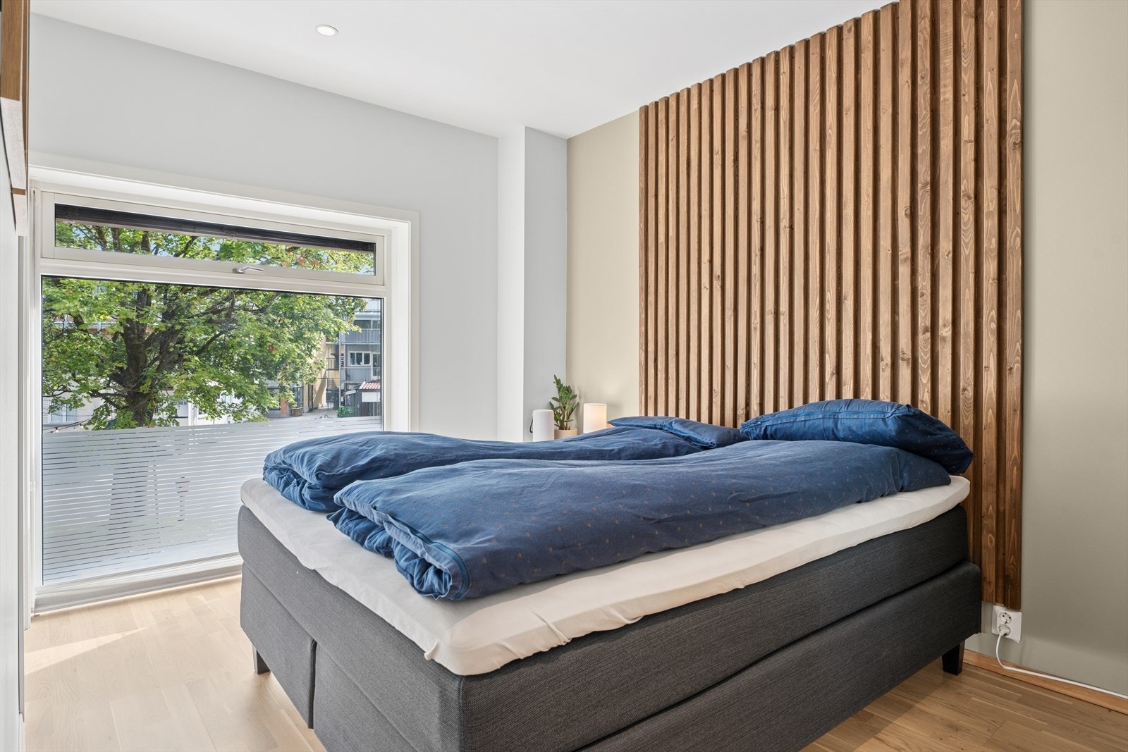 Soverommet er av god størrelse med en moderne sengegavl av spiler og et stort vindu som rammer inn utsikten over Panparken. Galleribilde