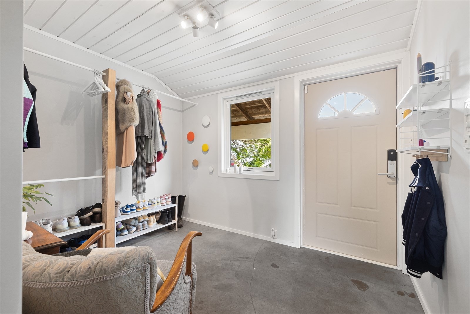 Boligen har en romslig og innbydende entré med moderne microsement på gulvet og varme som gir en lun velkomst Galleribilde