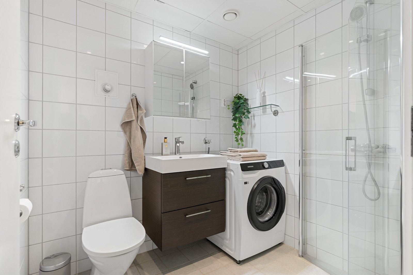 Badet er helfliset og utstyrt med dusjsone, servant og toalett. Galleribilde