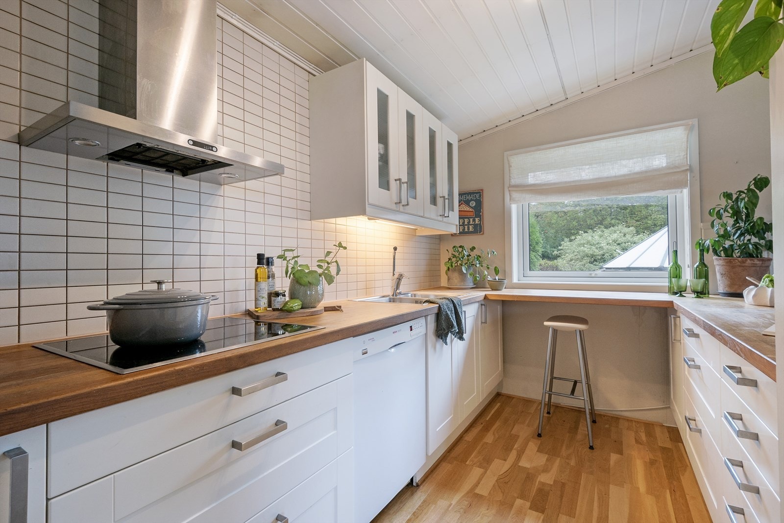 Pent kjøkken med spiseplass ved kjøkkenvinduet. Galleribilde