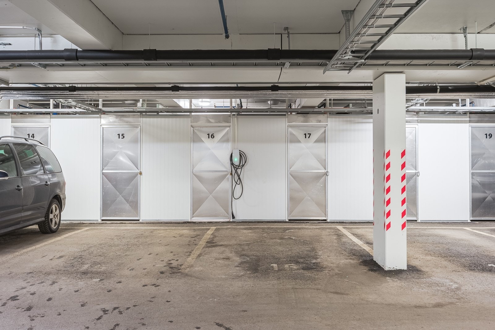 Leiligheten disponerer en fast parkeringsplass med privat elbil-lader i felles parkeringskjeller. Ved parkeringsplassen finner man også boden som tilhører leiligheten, begge merket med nr. 16. Galleribilde