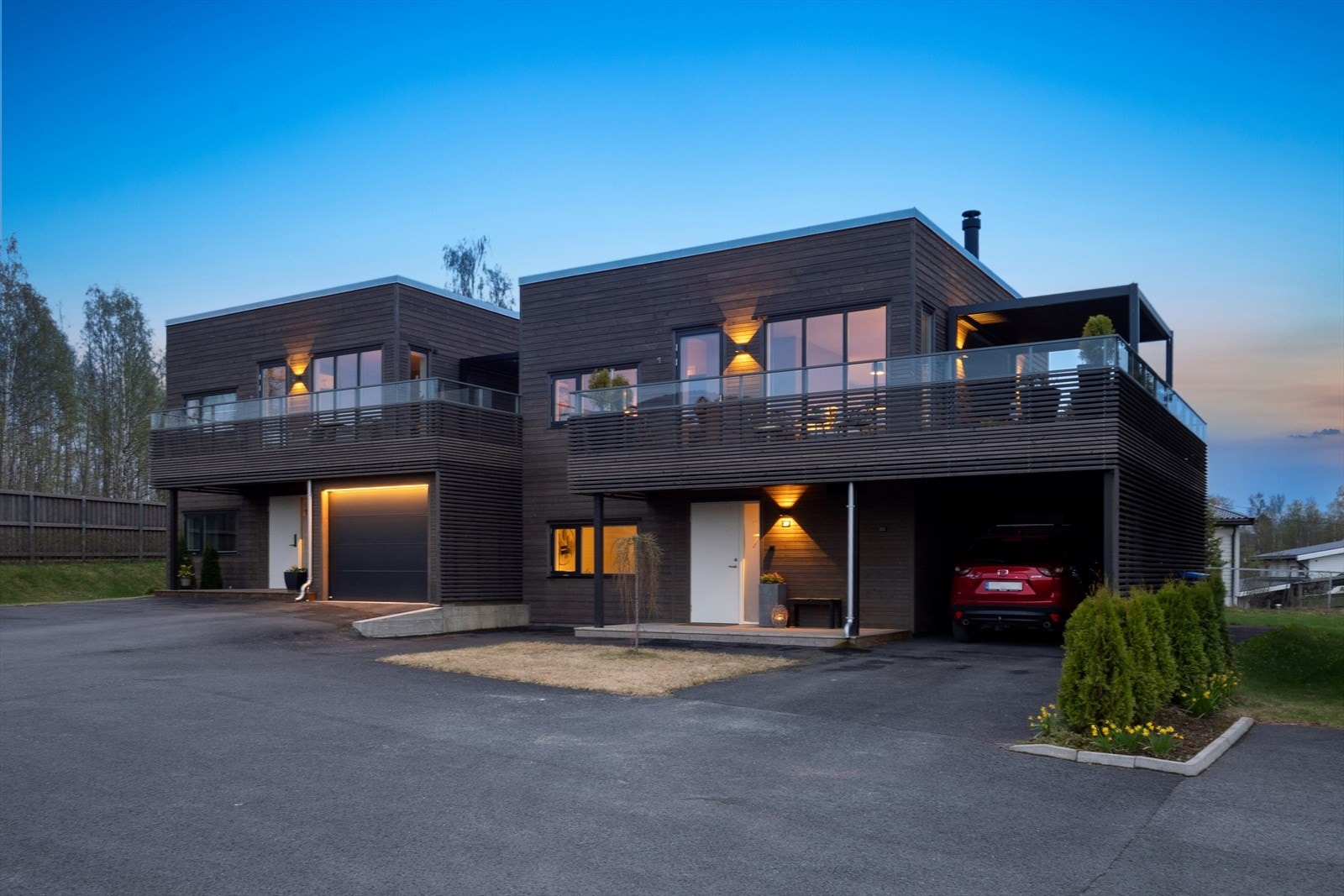 Det er asfaltert dekke foran inngang. Carport med el-billader og to biloppstillingsplasser. Galleribilde