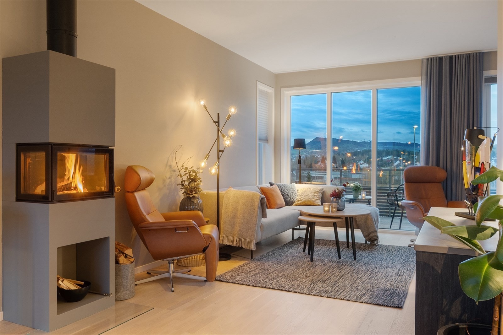 Lun og gjennomgående stue i hovedetasjen. Vedovn sentralt plassert i rommet. Galleribilde