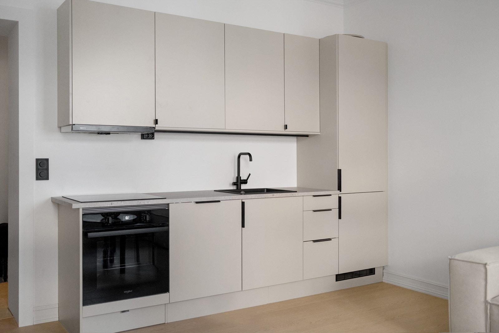 Kjøkkenet er godt utstyrt. Innredning med slette fronter i beige, laminert benkeplate med nedfelt koketopp og oppvaskkum av kompositt Galleribilde