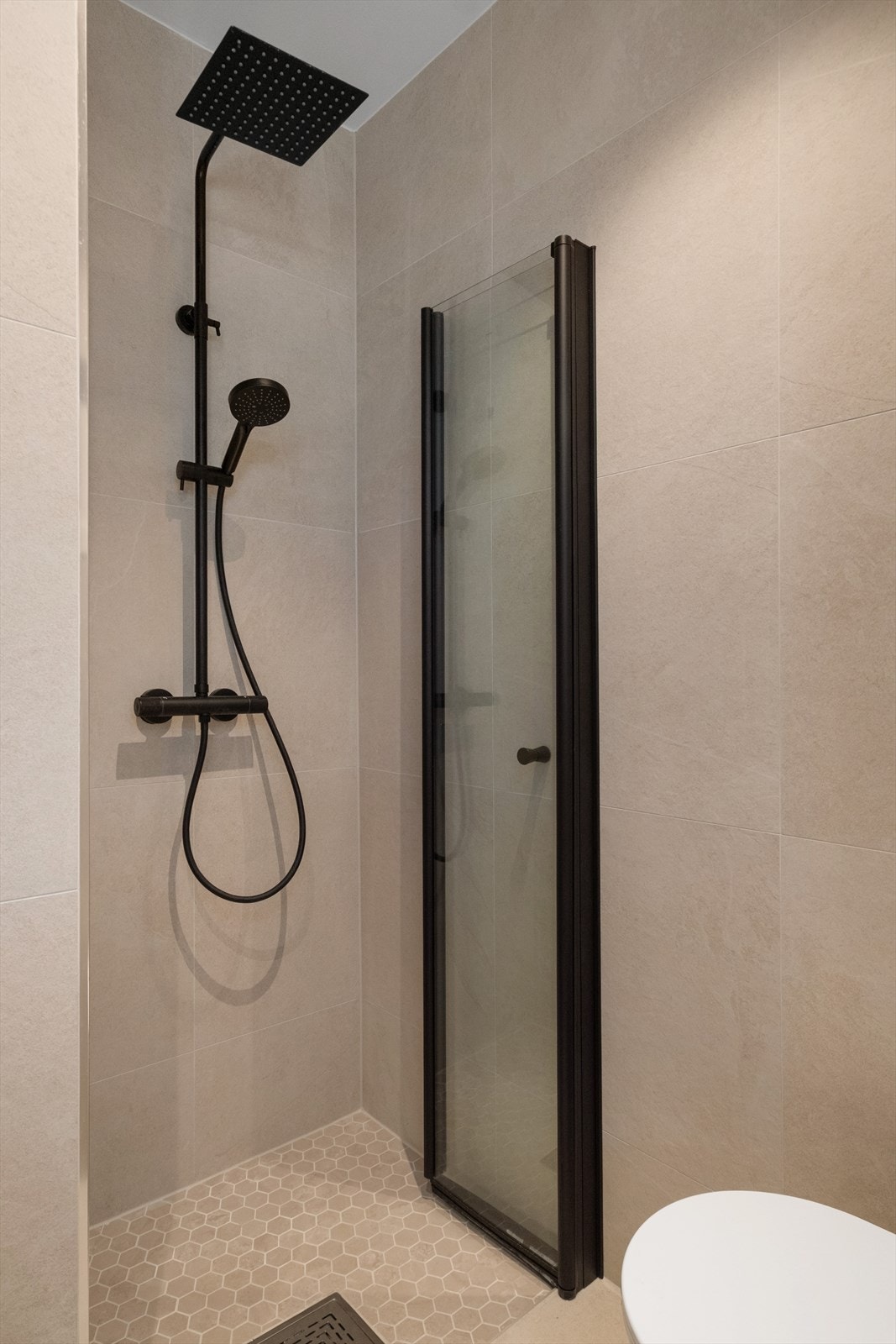 Romslig dusjhjørne og innfellbare dusjdører i svart utførelse Galleribilde